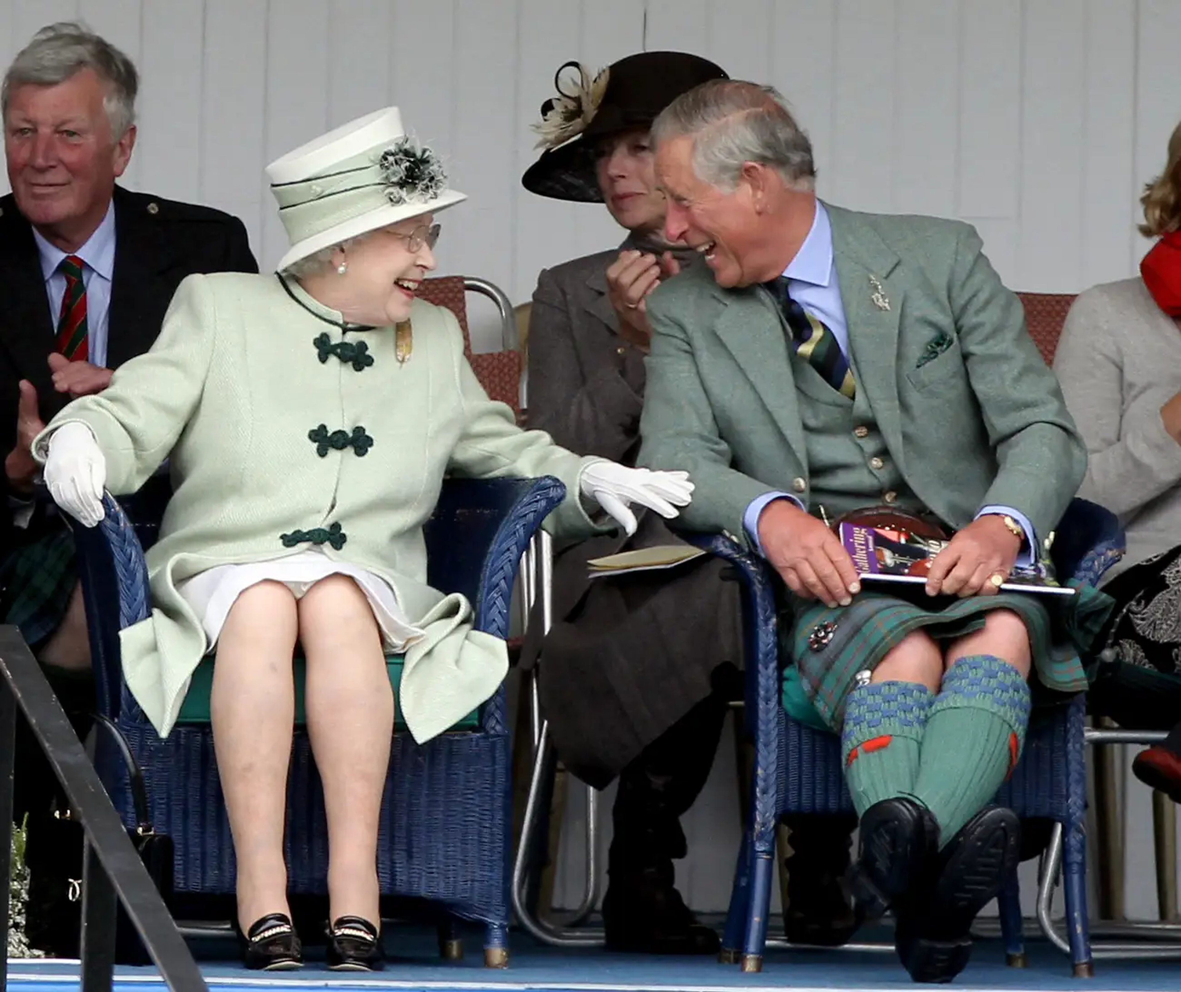 La reina Isabel y el príncipe Carlos, príncipe de Gales, se ríen mientras ven el tira y afloja durante los 'Braemar Highland Games' en Braemar, Escocia, en 2010.