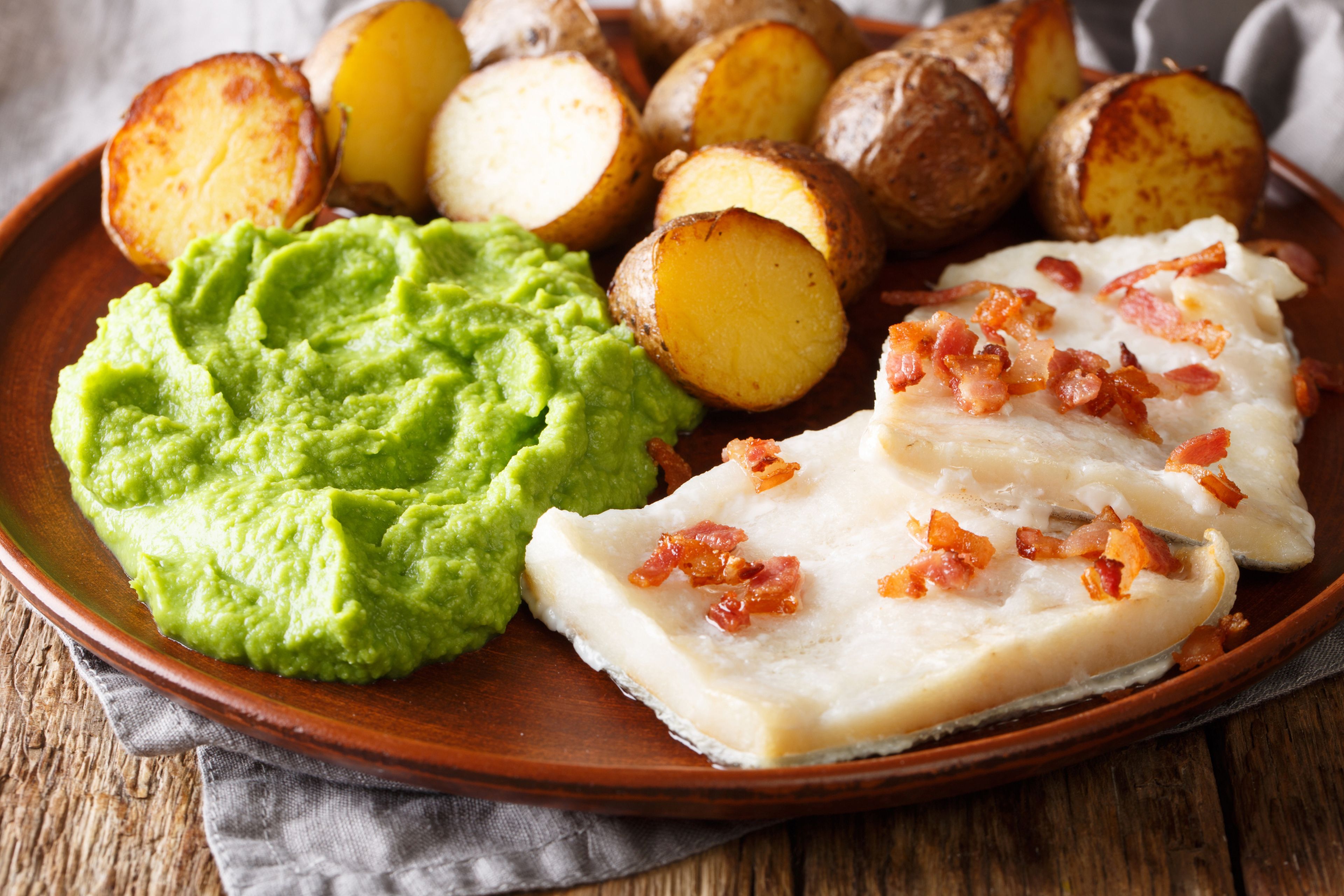 Popular comida escandinava: lutefisk de bacalao con puré de guisantes, patatas al horno y tocino.