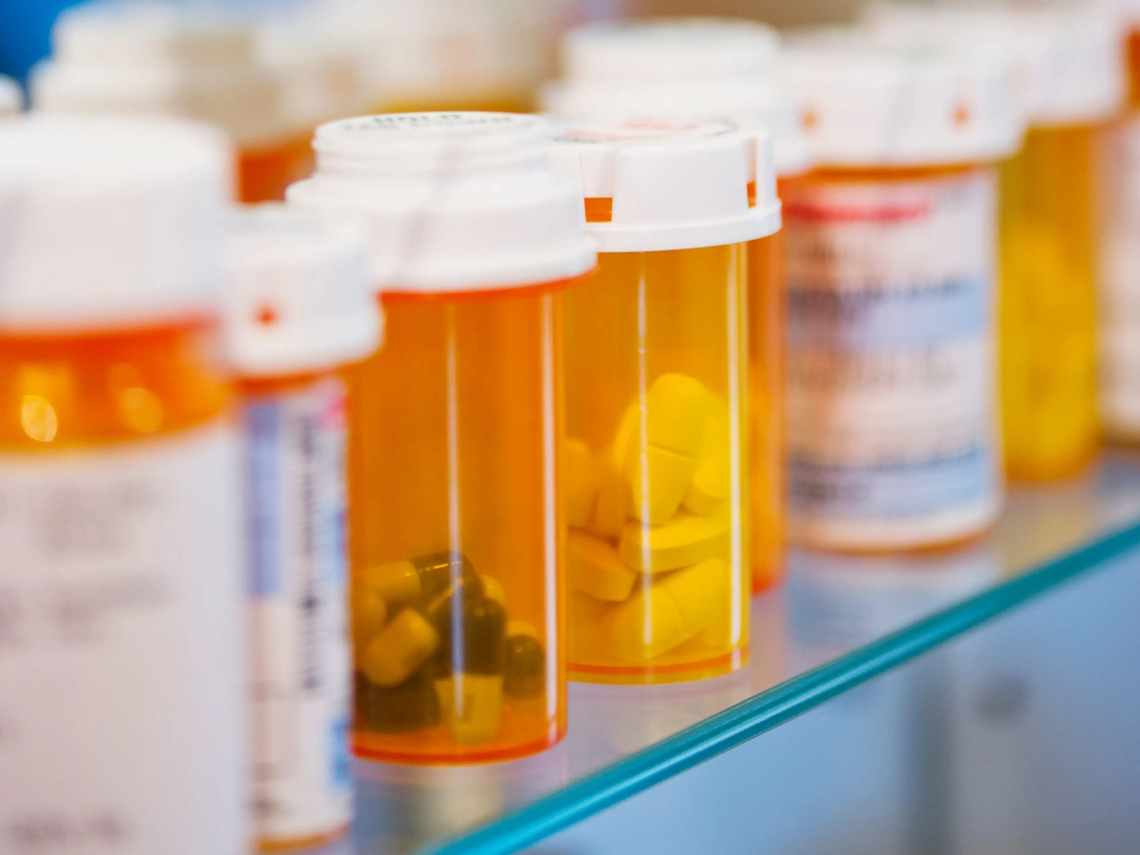 Pill bottles on a shelf in a medicine cabinet