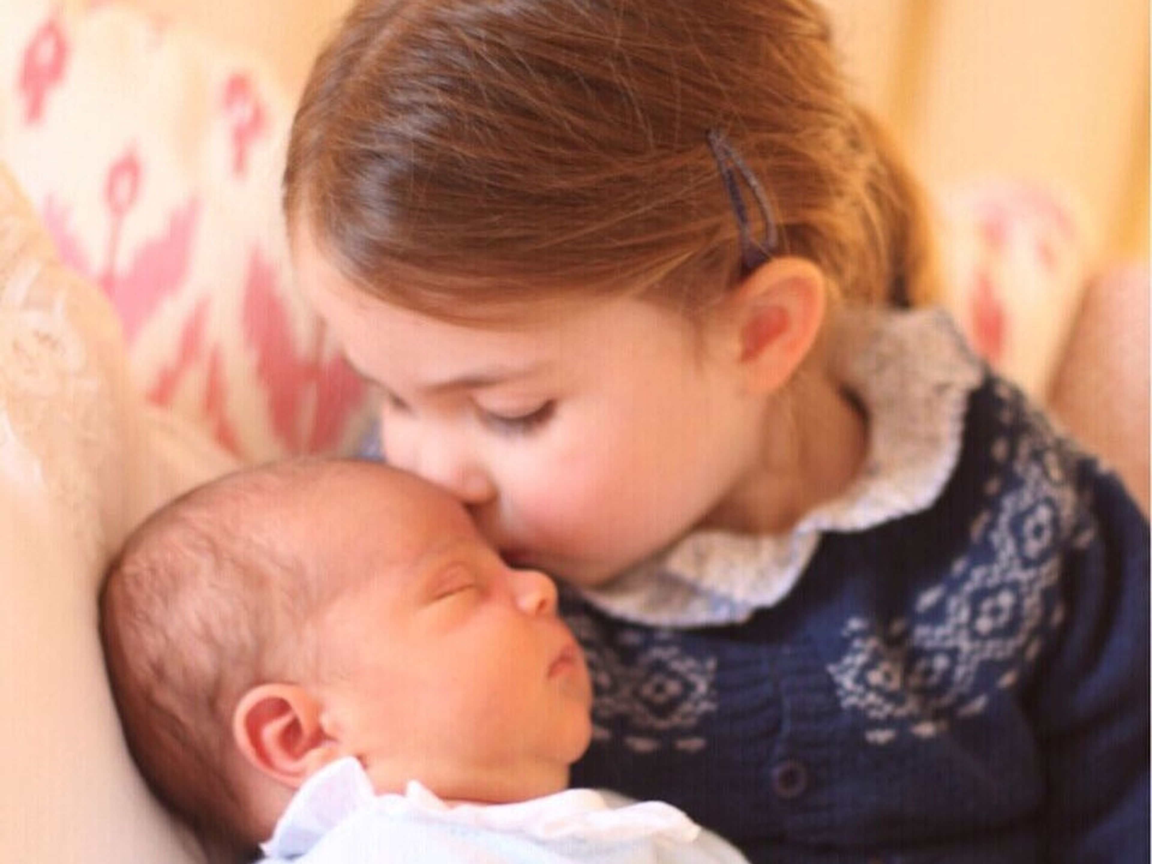La princesa Charlotte dándole un beso a su hermano pequeño, Louis.