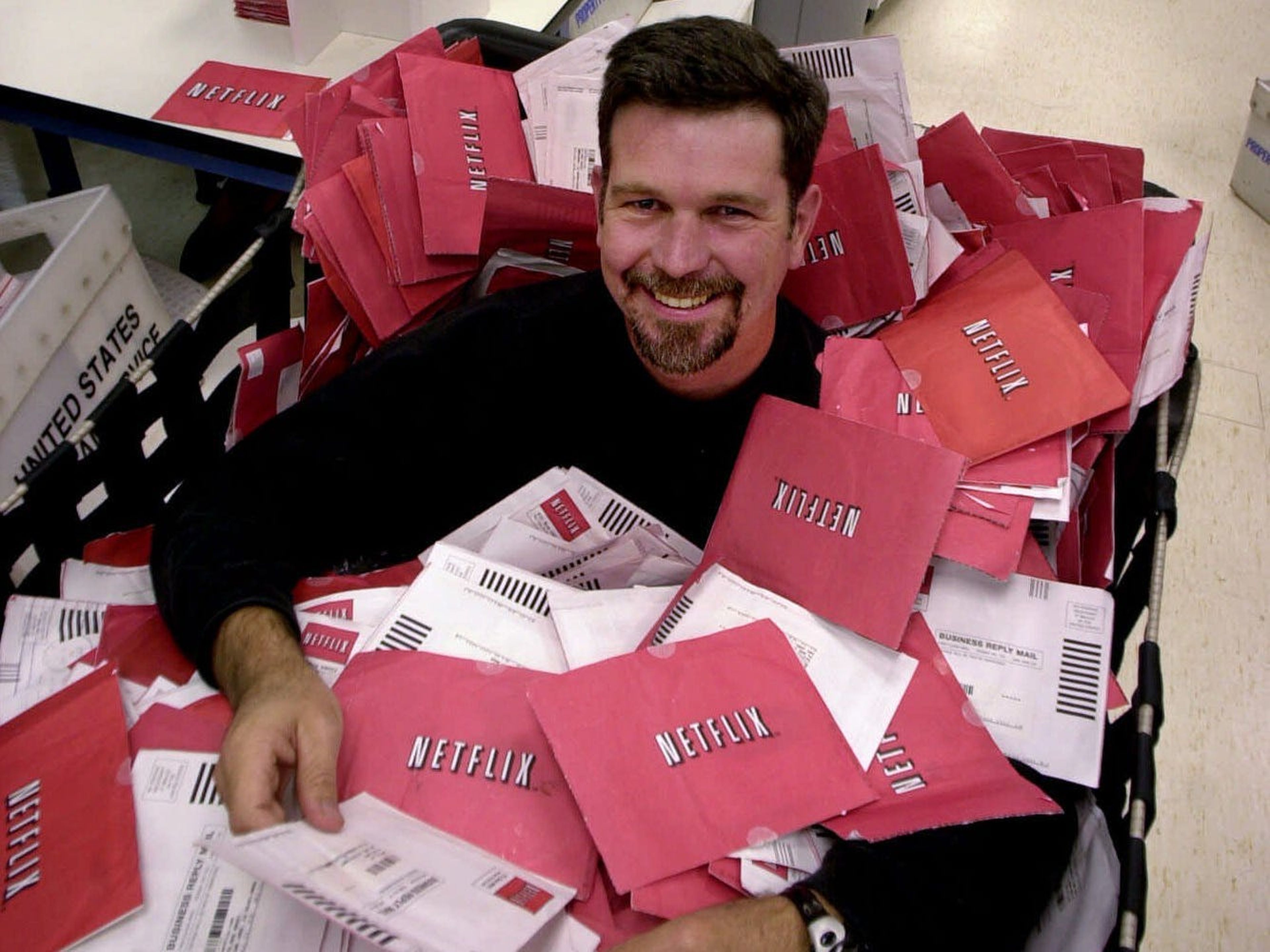 Reed Hastings, codirector general de Netflix, junto a una pila de DVD