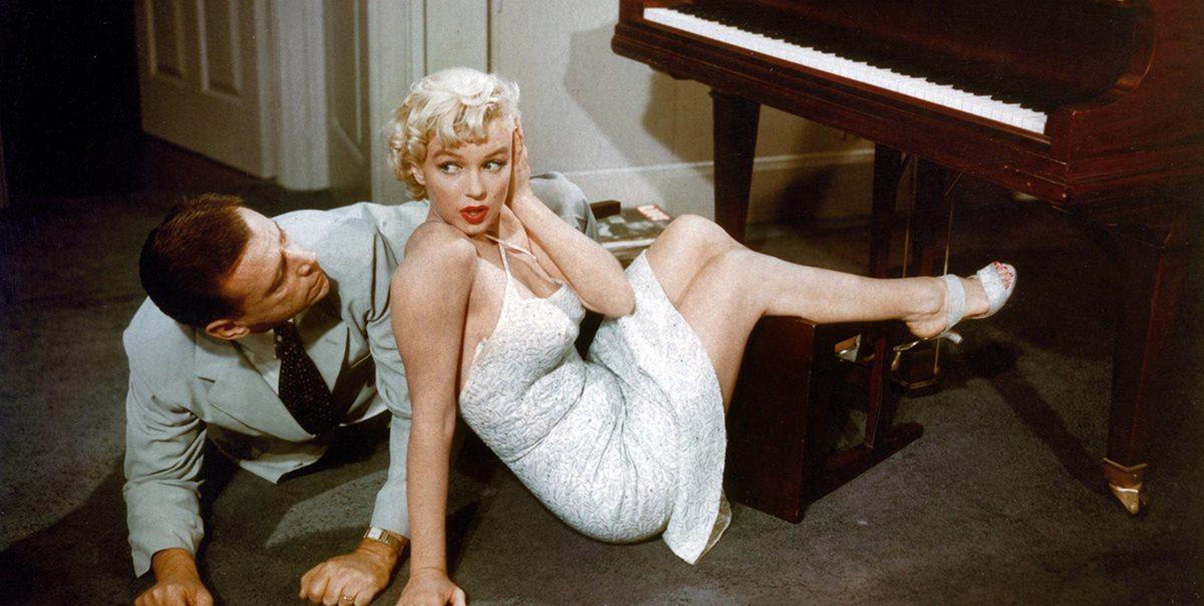 Tom Ewell y Marilyn Monroe en el suelo tras caerse de un banco de piano en 'La tentación vive arriba'.