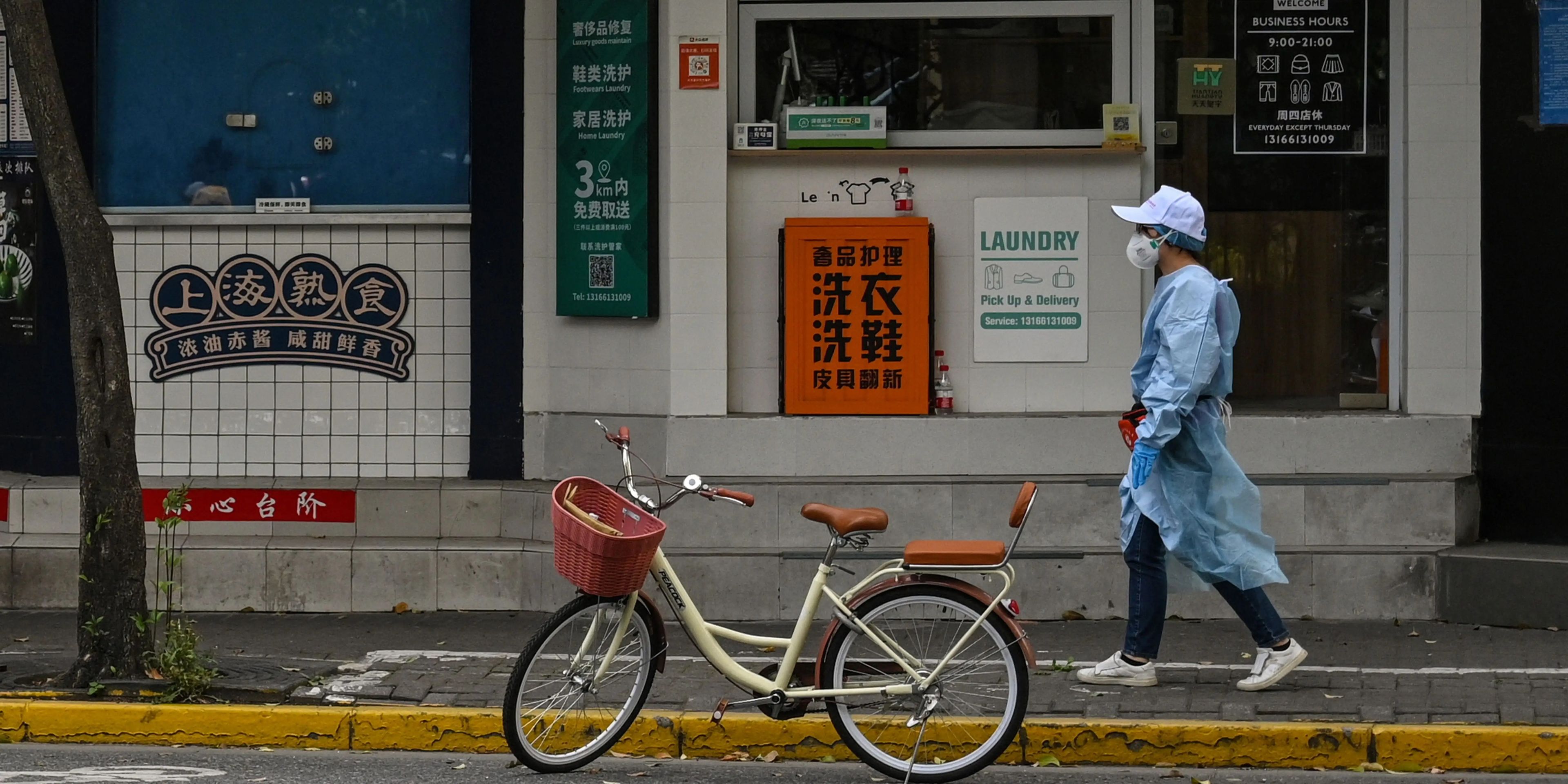 Un trabajador con EPI en una calle vacía de Shanghái (China)