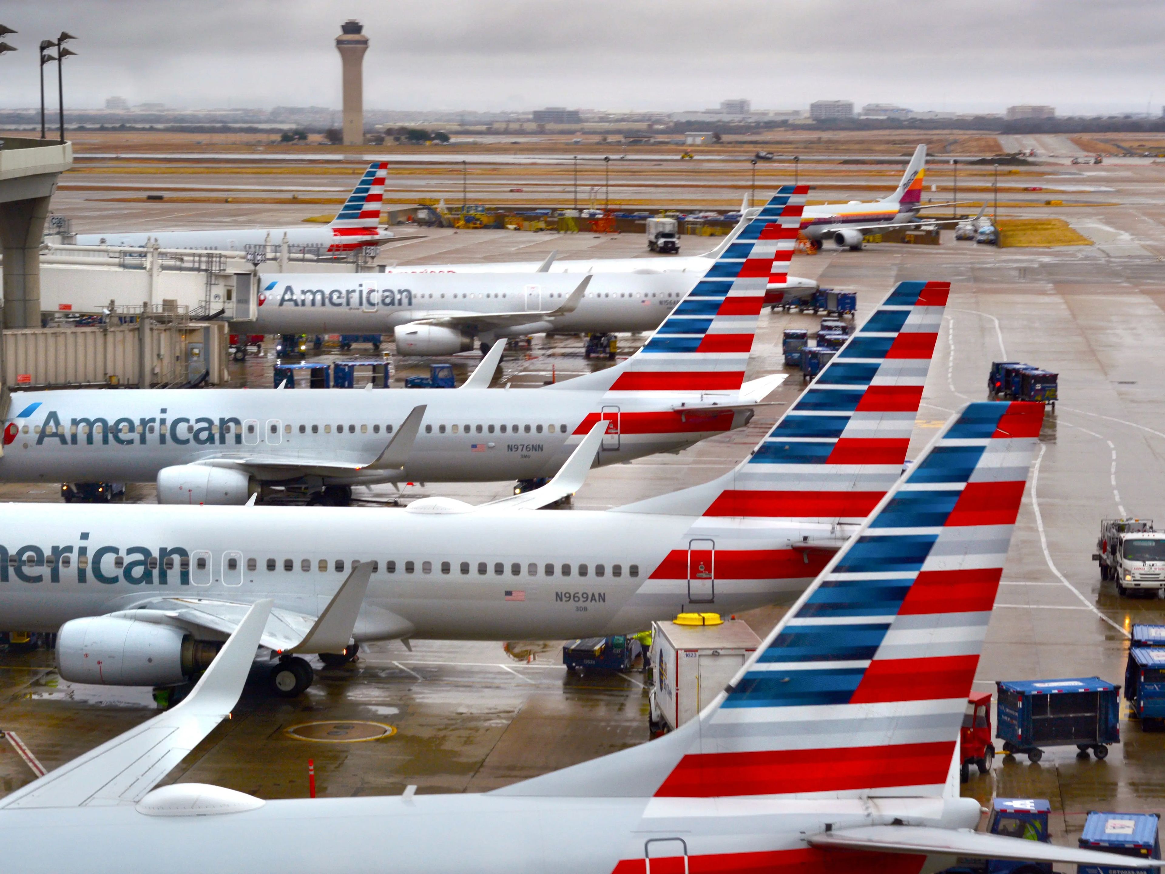 Varios aviones de American Airlines atracados en un aeropuerto.