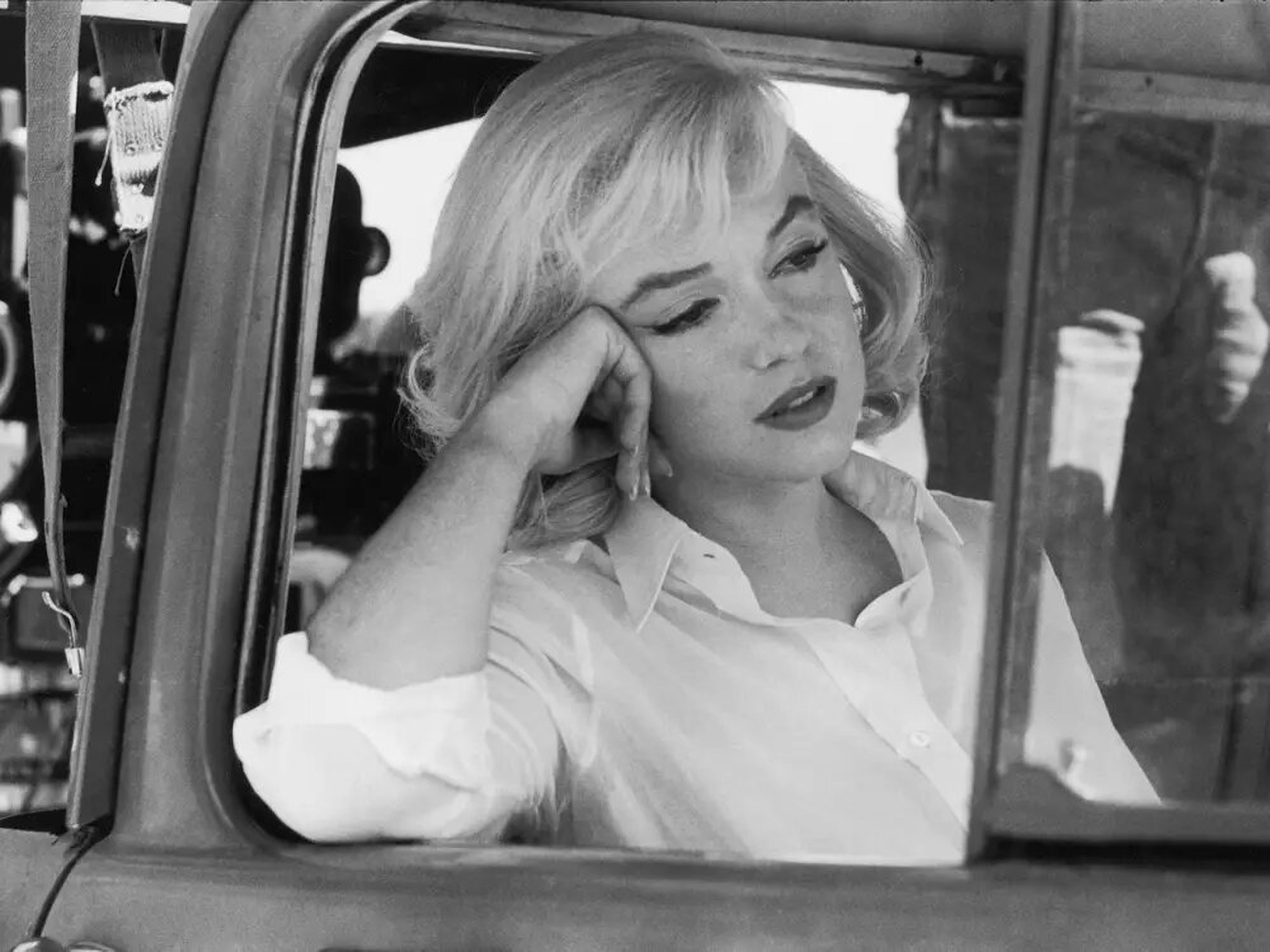 Marilyn Monroe se asoma por el marco de la ventana abierta de un automóvil en el set de la película.