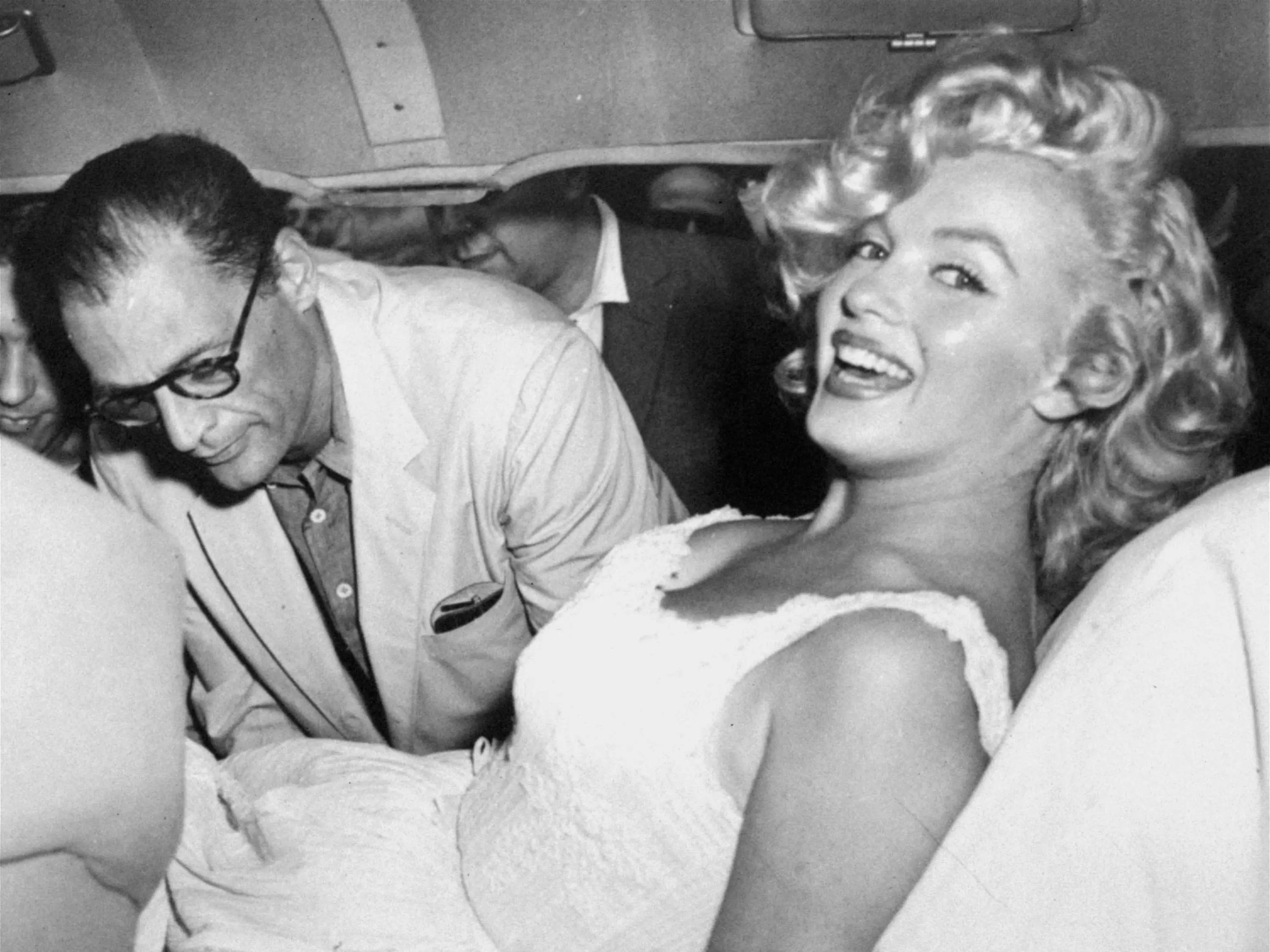 Marilyn Monroe acomodada en un coche por su marido Arthur Miller después de que la actriz fuese hospitalizada debido a un aborto involuntario, el 10 de agosto de 1957.