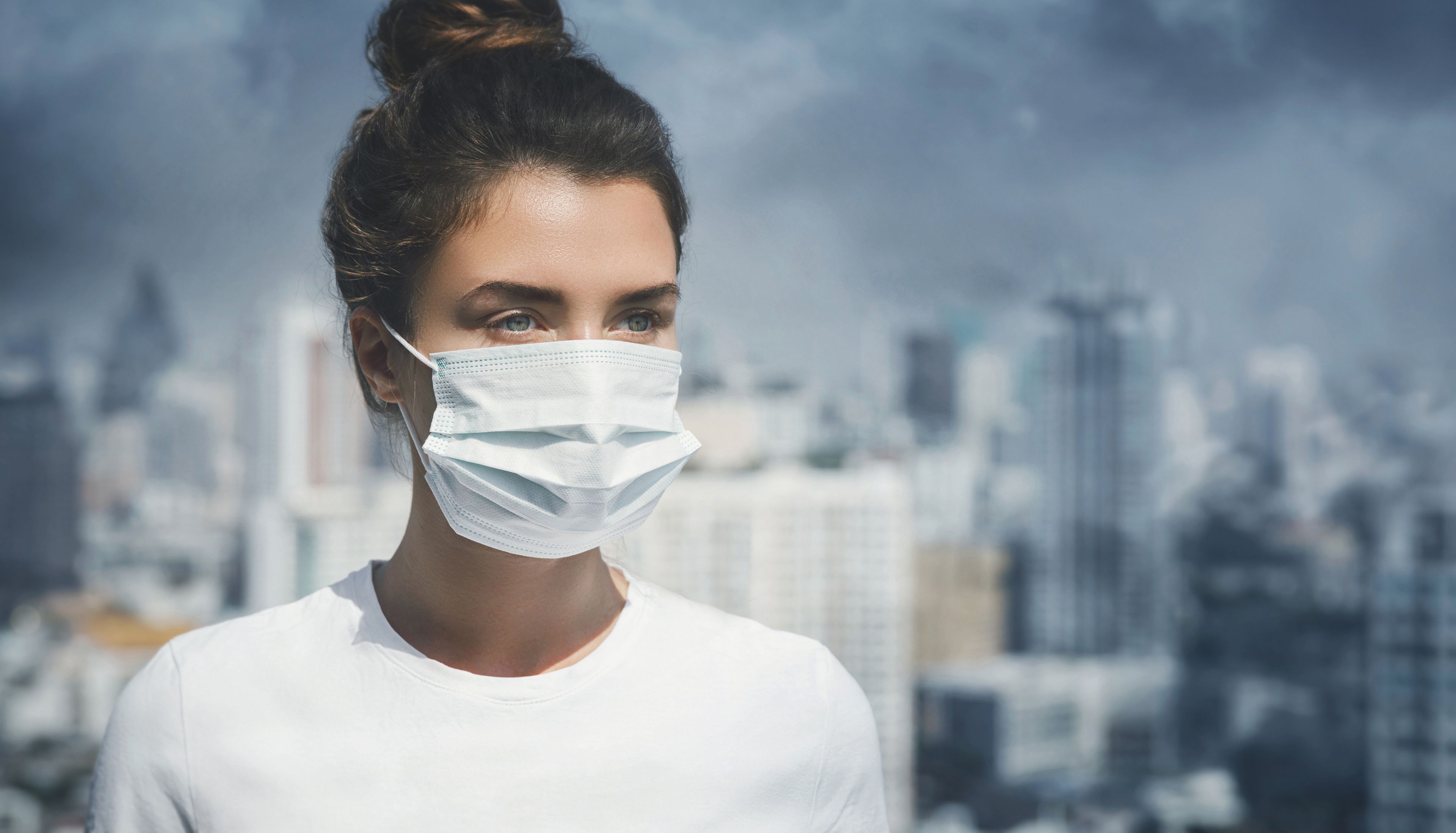 Mujer con mascarilla entre contaminación para evitar enfermedades por cambio climático