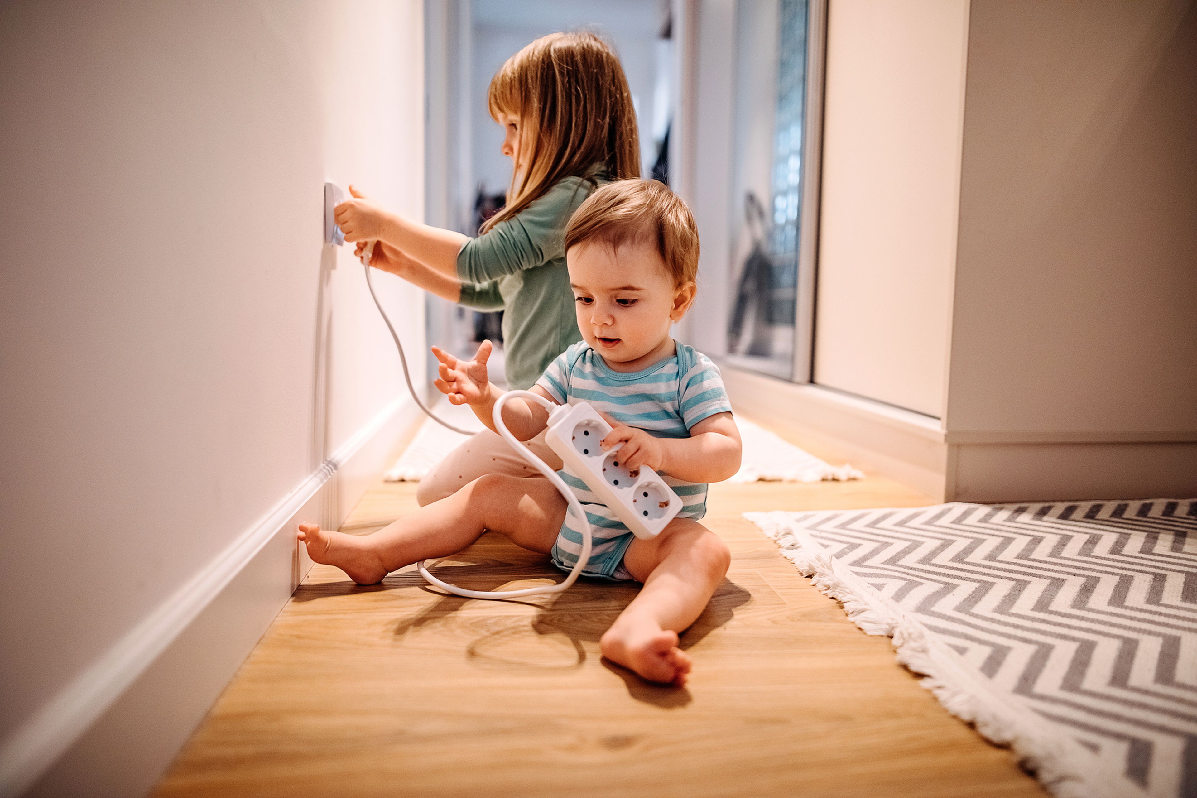 Un niño y una niña juegan con cables y enchufes.