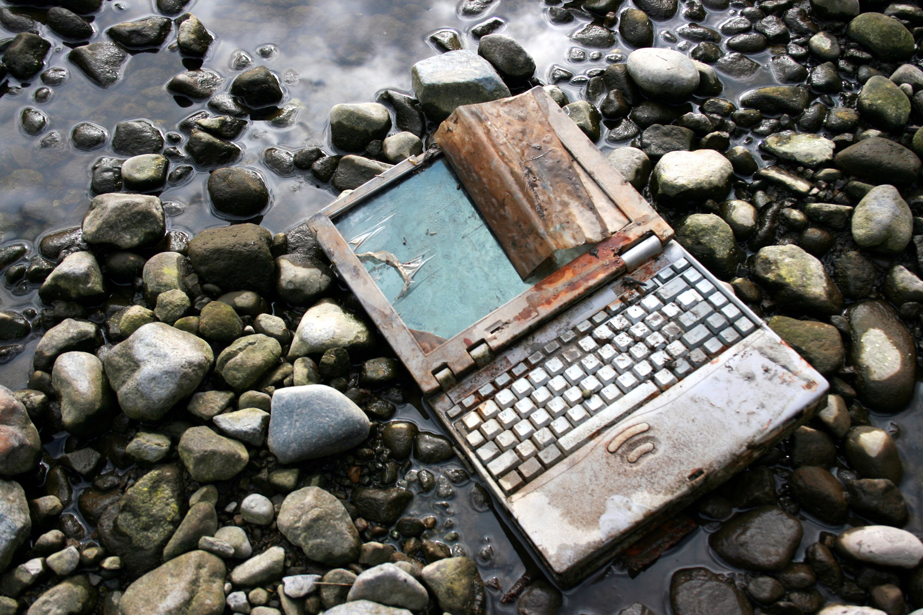 Un ordenador portátil oxidado en el lecho de un río.