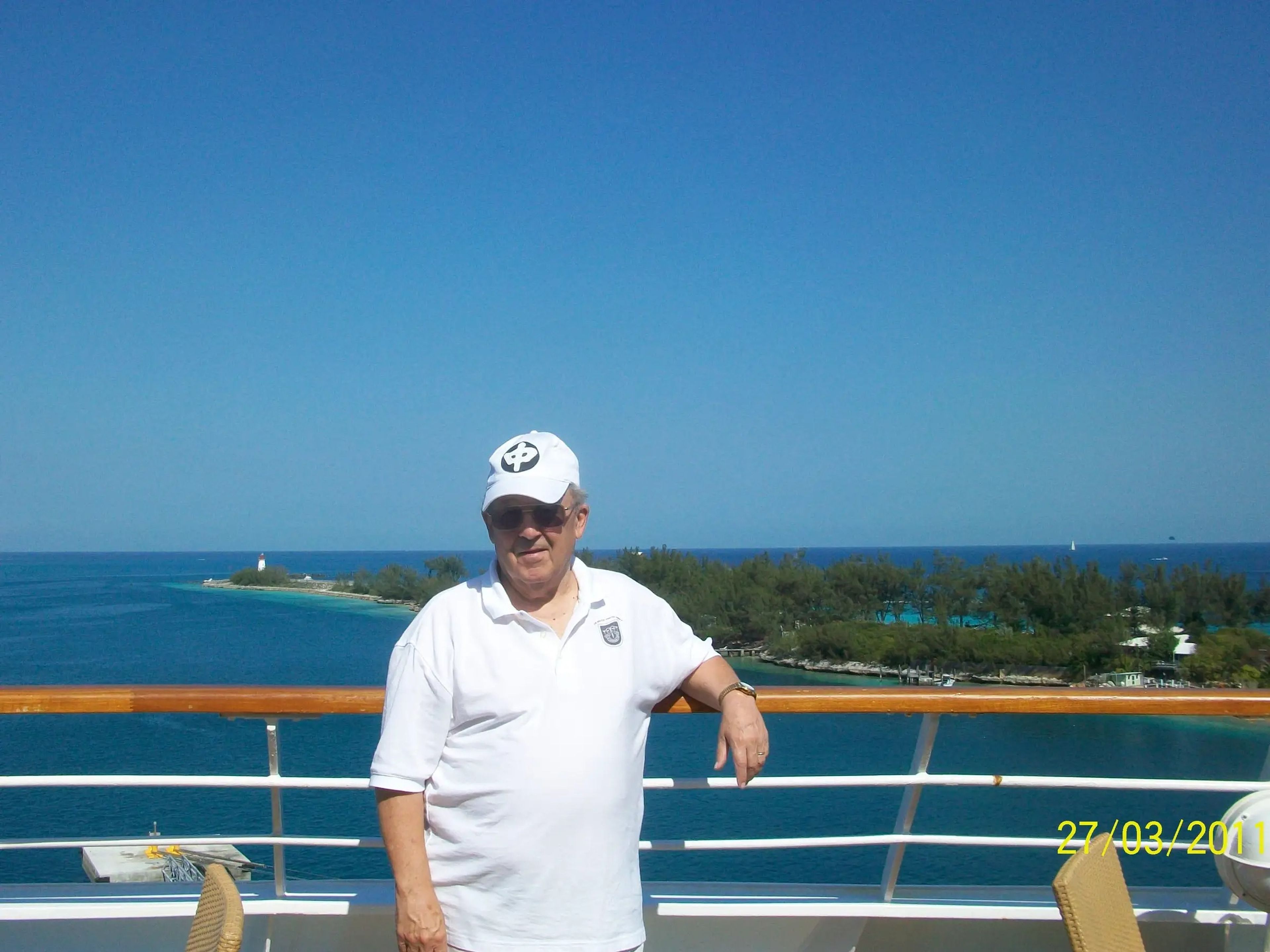 robert l willett posing for a photo on the deck of a cruise ship in front of blu skies