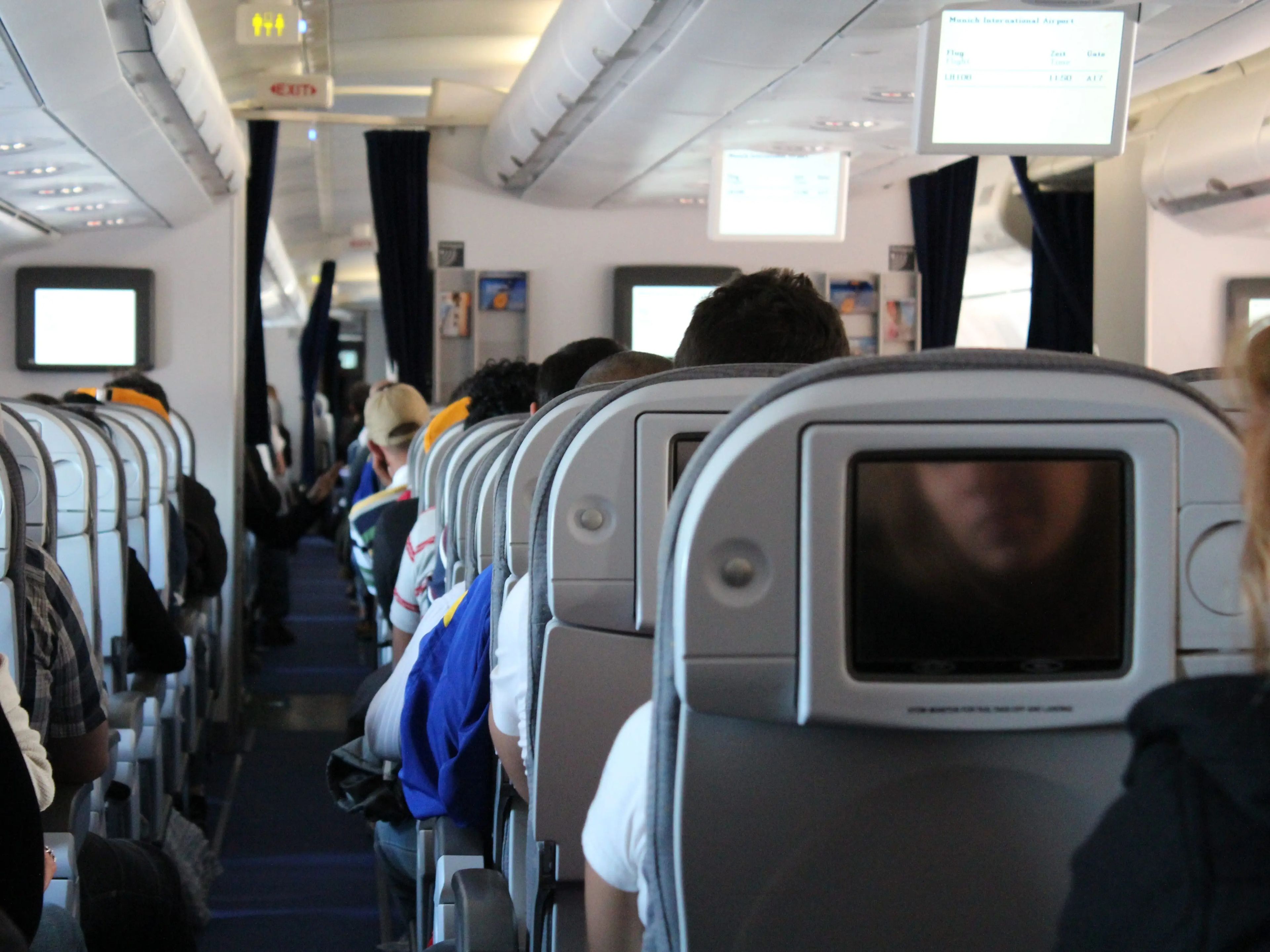 A stock image of people sitting in seats on a plane.