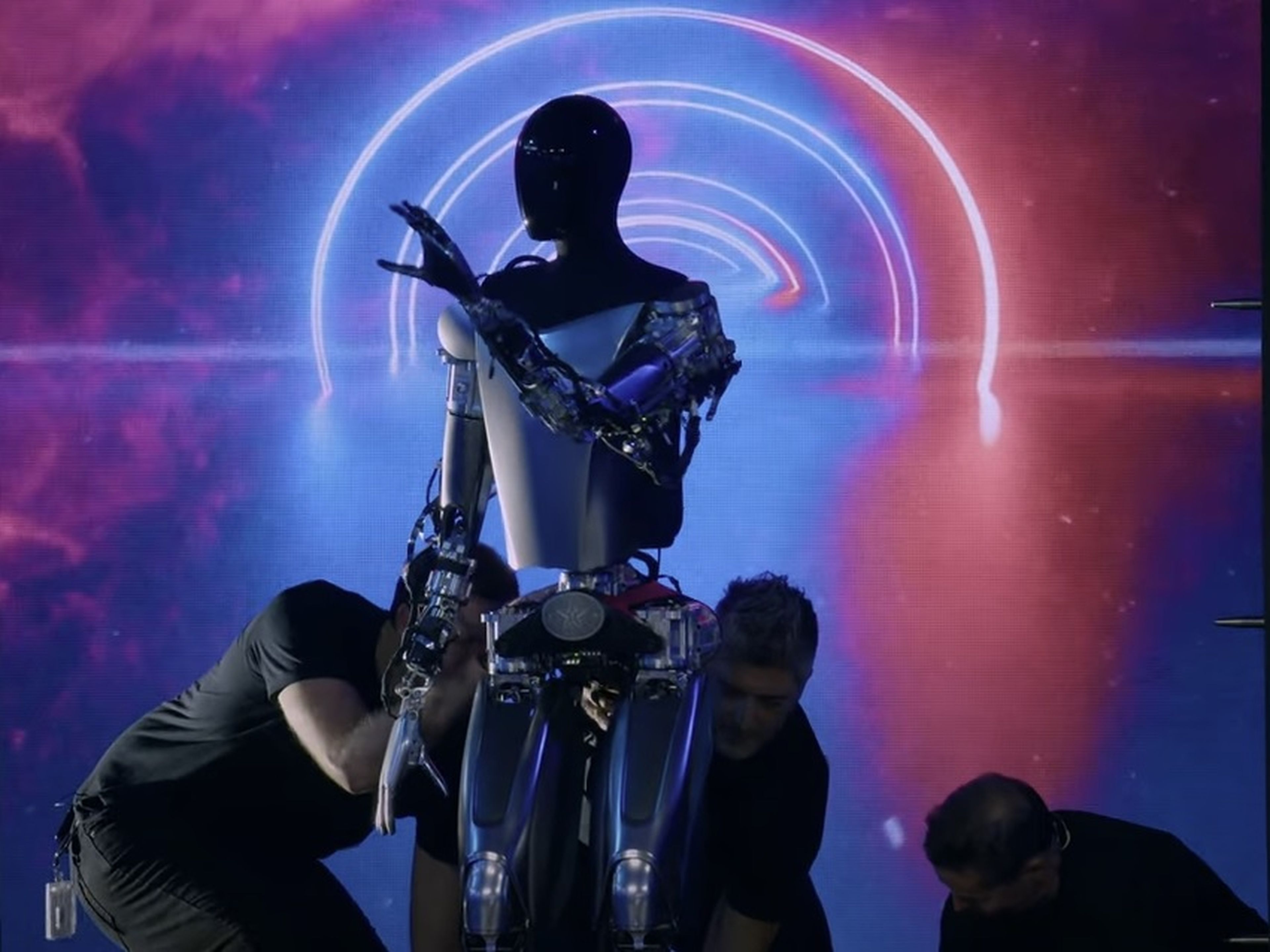 el robot humanoide de Tesla, sujeto por varios empleados.