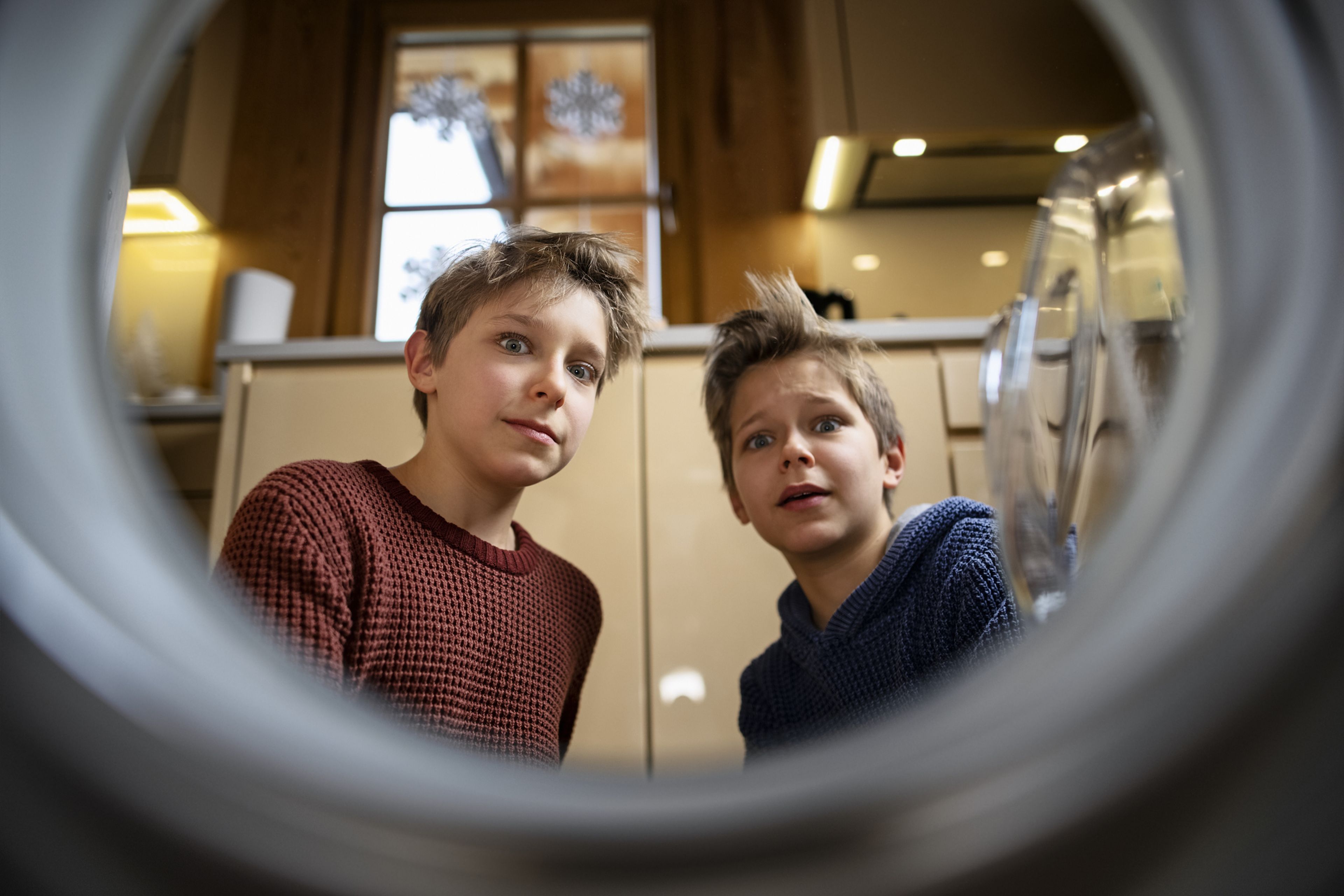 2 chicos miran con asombro el interior de una nevera.