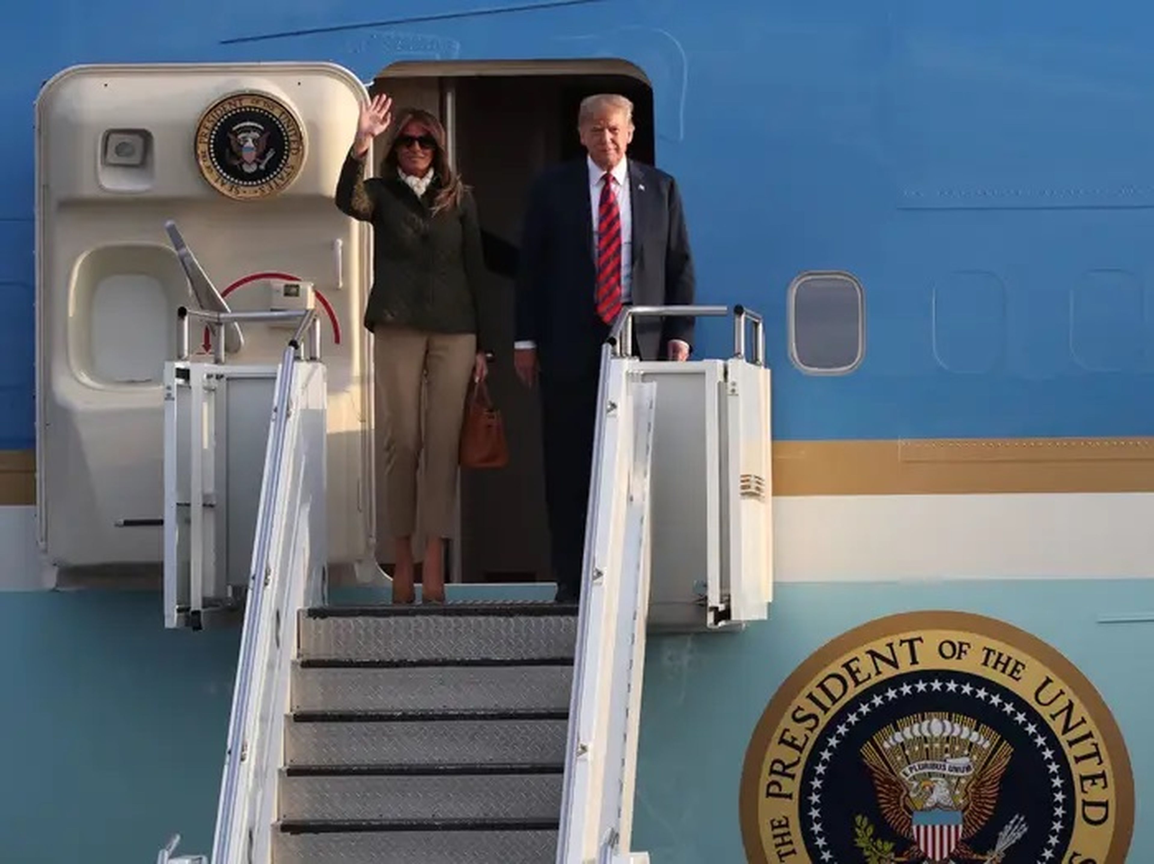 Melania y Donald Trump saludan desde el Air Force One.