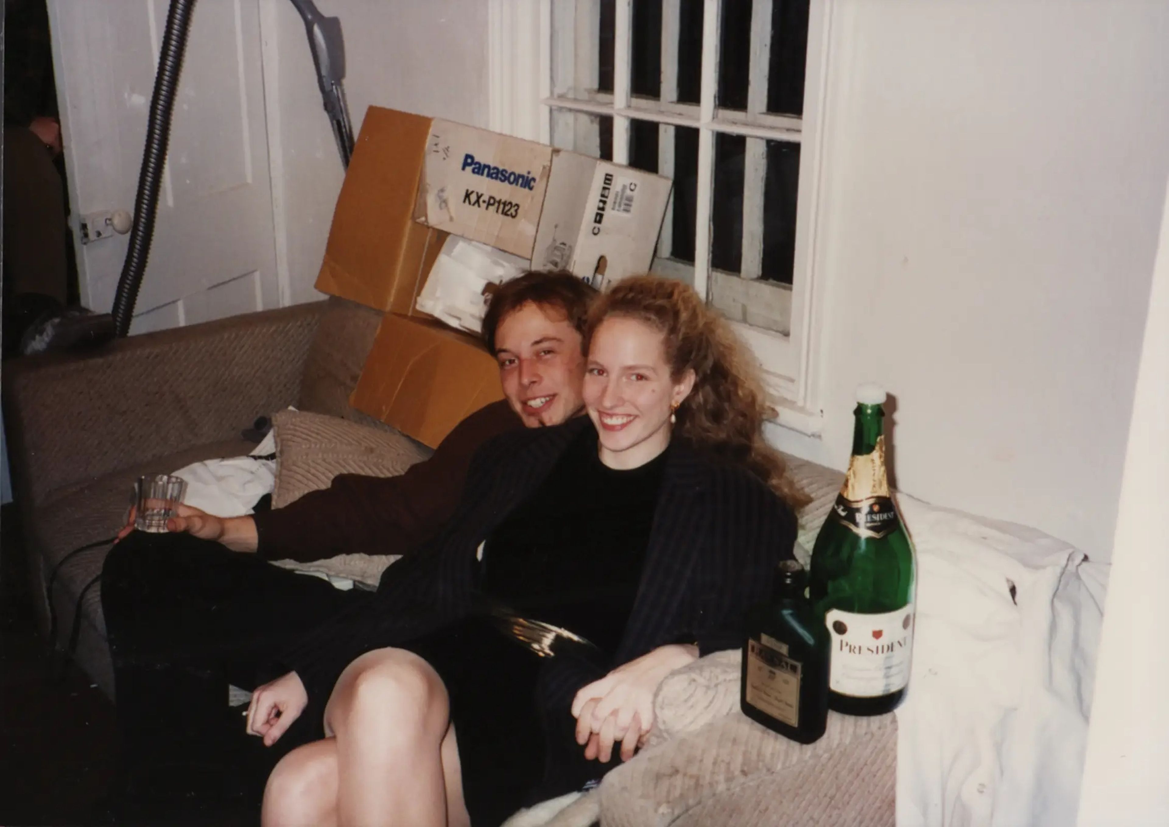 Elon Musk having a drink on a couch with his then-girlfriend.