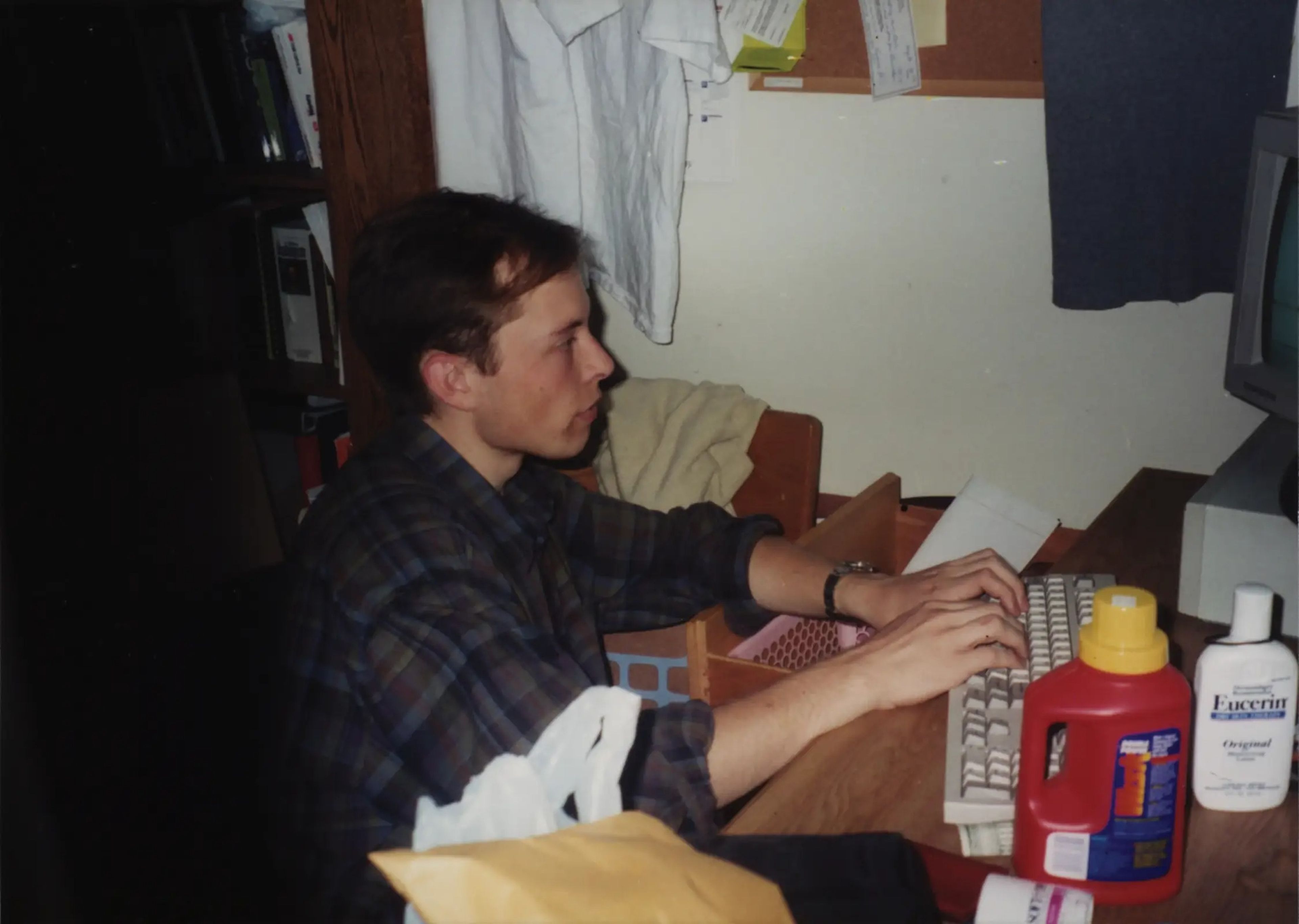 Elon Musk is seated at a computer in his girlfriend’s Quadrangle dorm room in 1995