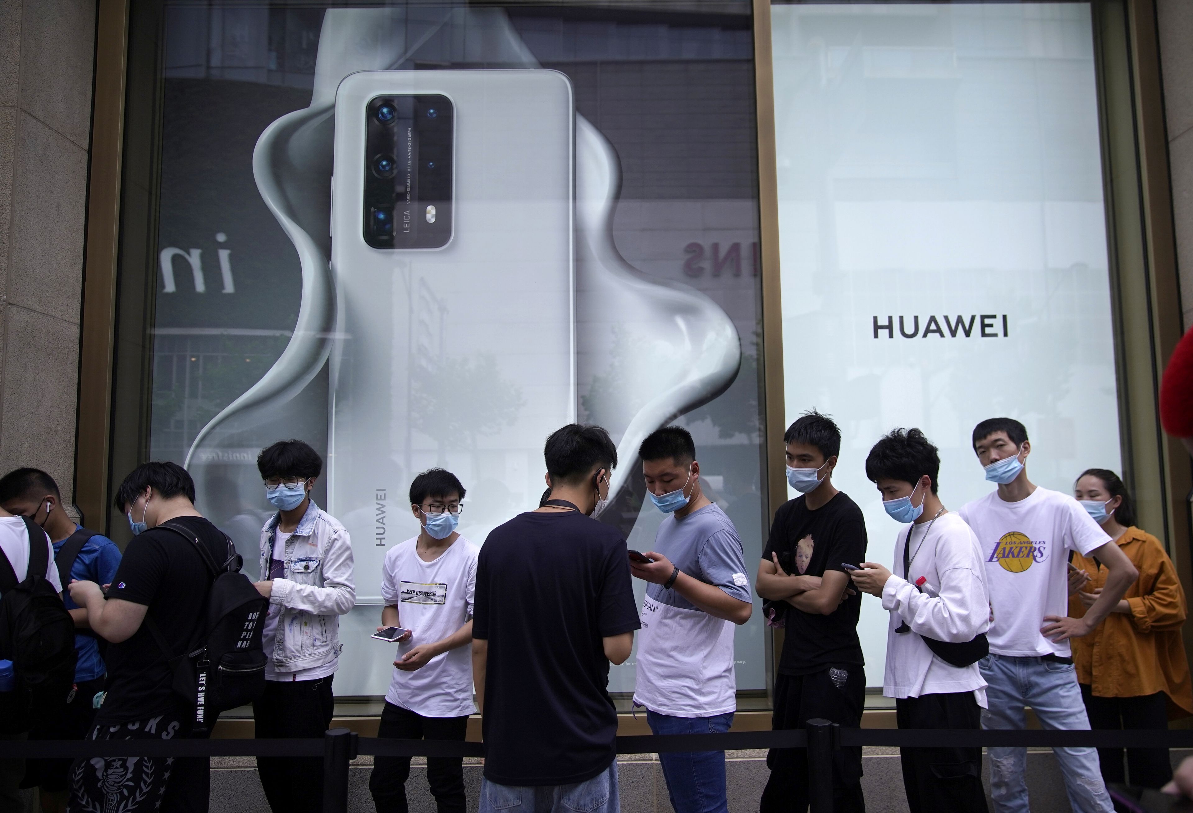 Jóvenes frente a una tienda de Huawei en Shanghai.