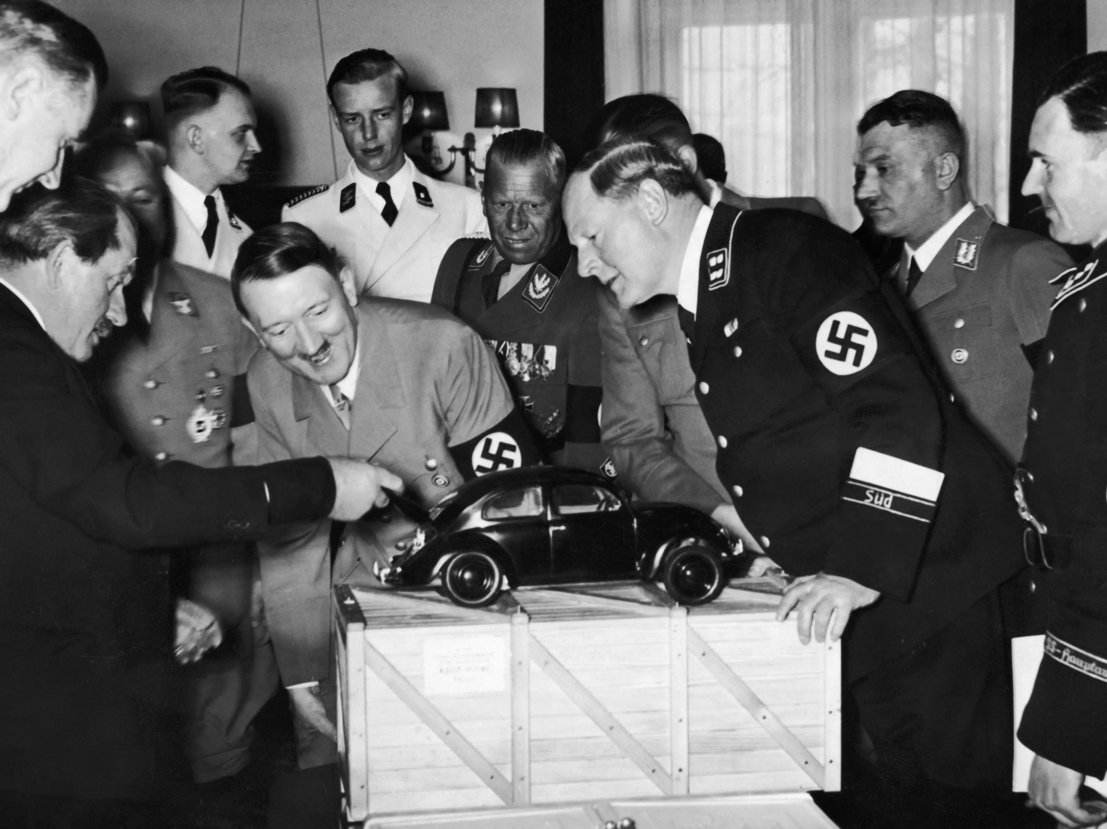 El líder nazi Adolf Hitler (1889 - 1945) admira un modelo de coche Volkswagen con el diseñador Ferdinand Porsche (izquierda). A la derecha, el mariscal de campo Huehnlein, el Dr. Ley, Schmeer y Werlin.