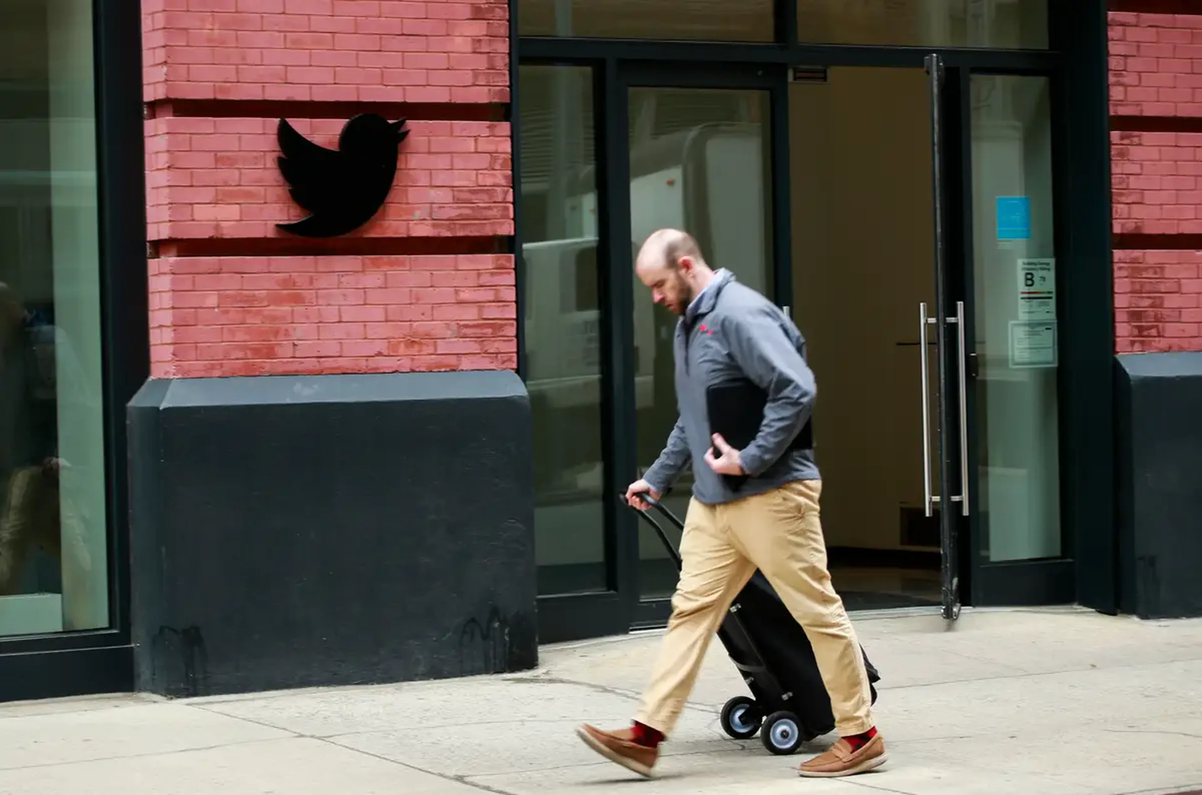 Un señor anda por fuera de las oficinas de Twitter