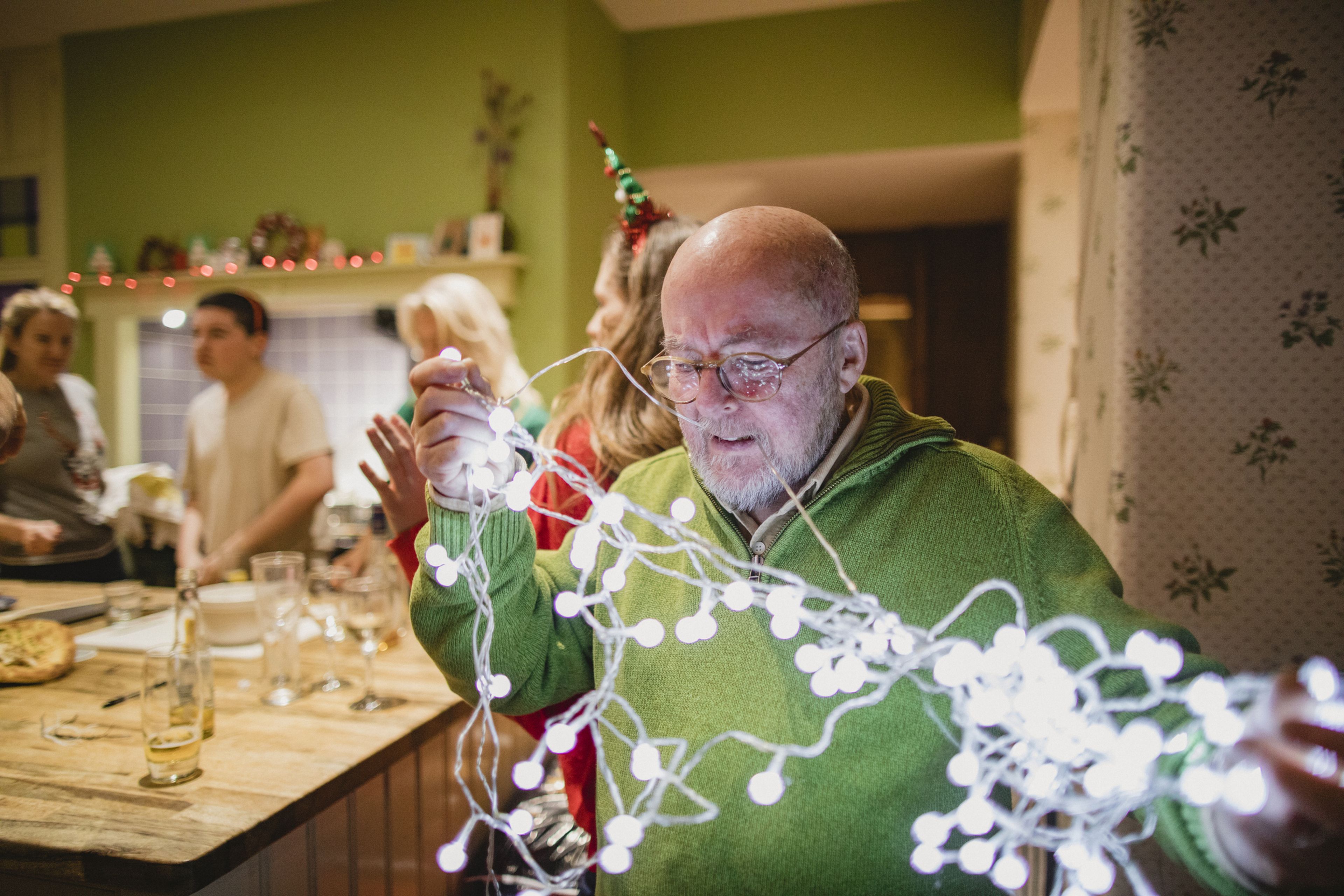 Un señor trata de desenredar las luces de Navidad.