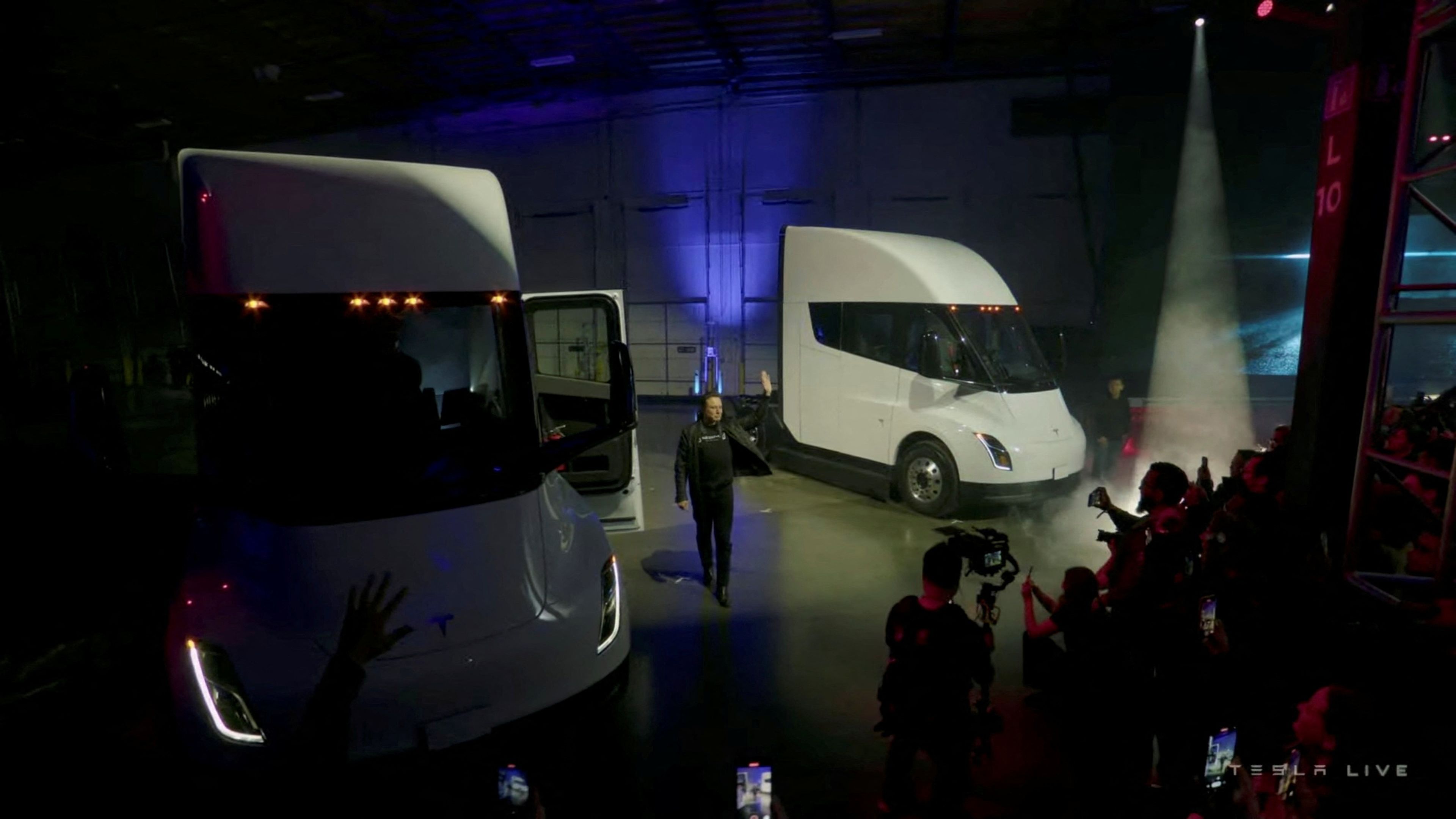 Elon Musk entre dos camiones de Tesla.