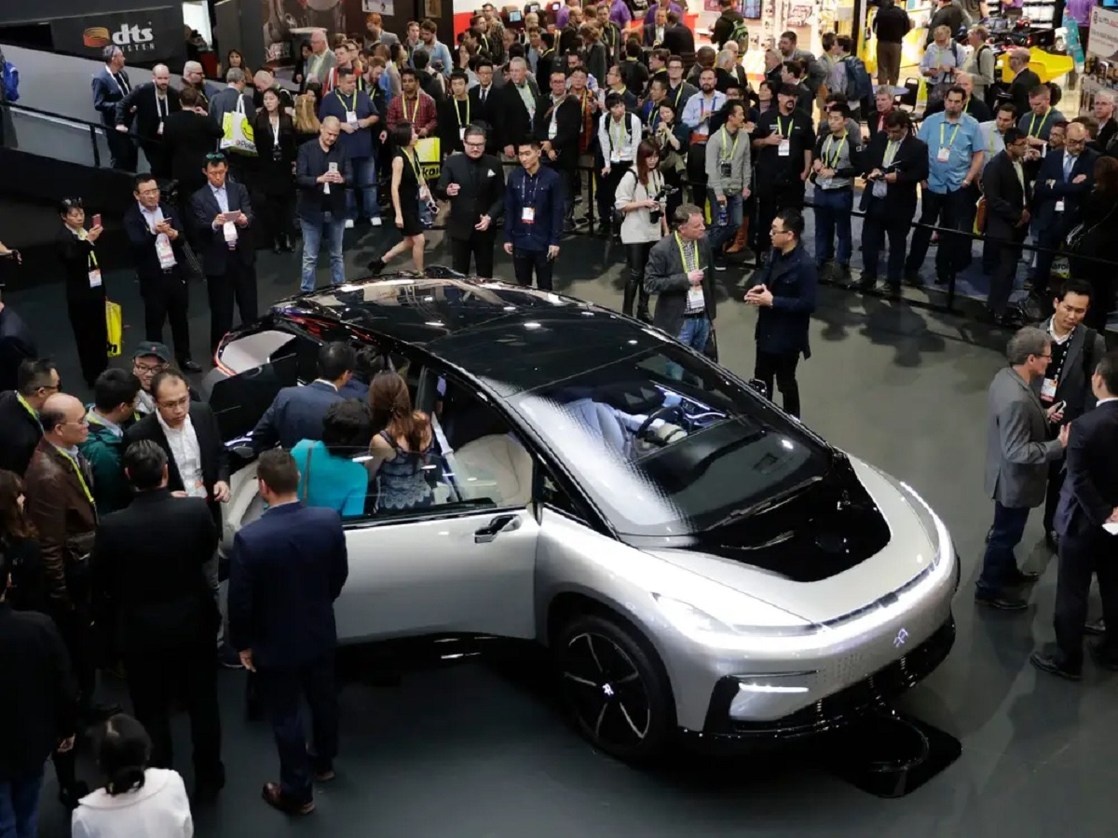 La gente se reúne alrededor del coche eléctrico FF91 de Faraday Future en el CES de 2017. 5 años después, la empresa ha experimentado todo tipo de retos. 
