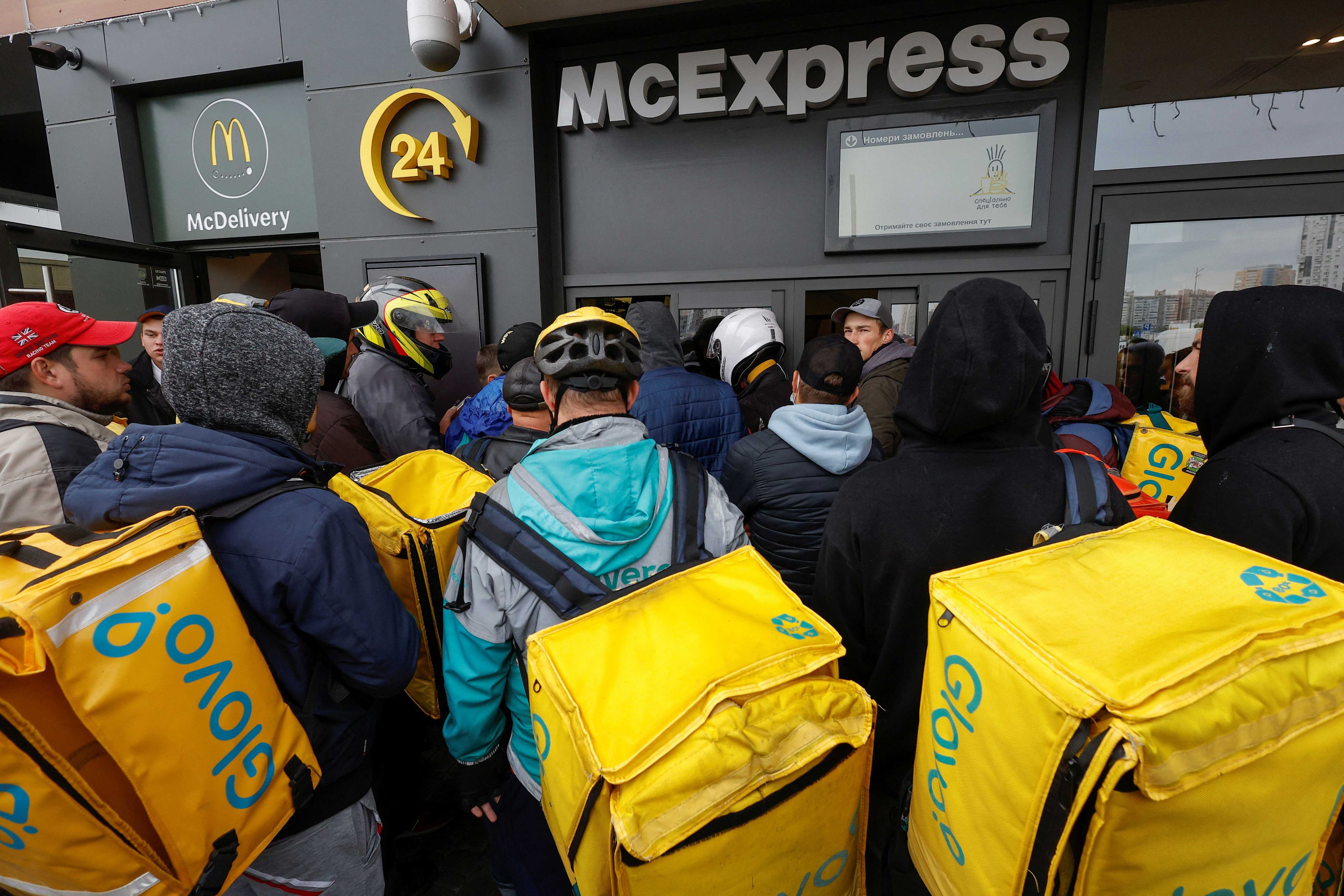 'Riders' de Glovo esperan para recoger pedidos fuera de un McDonald's, en Kiev, Ucrania, el 20 de septiembre de 2022.