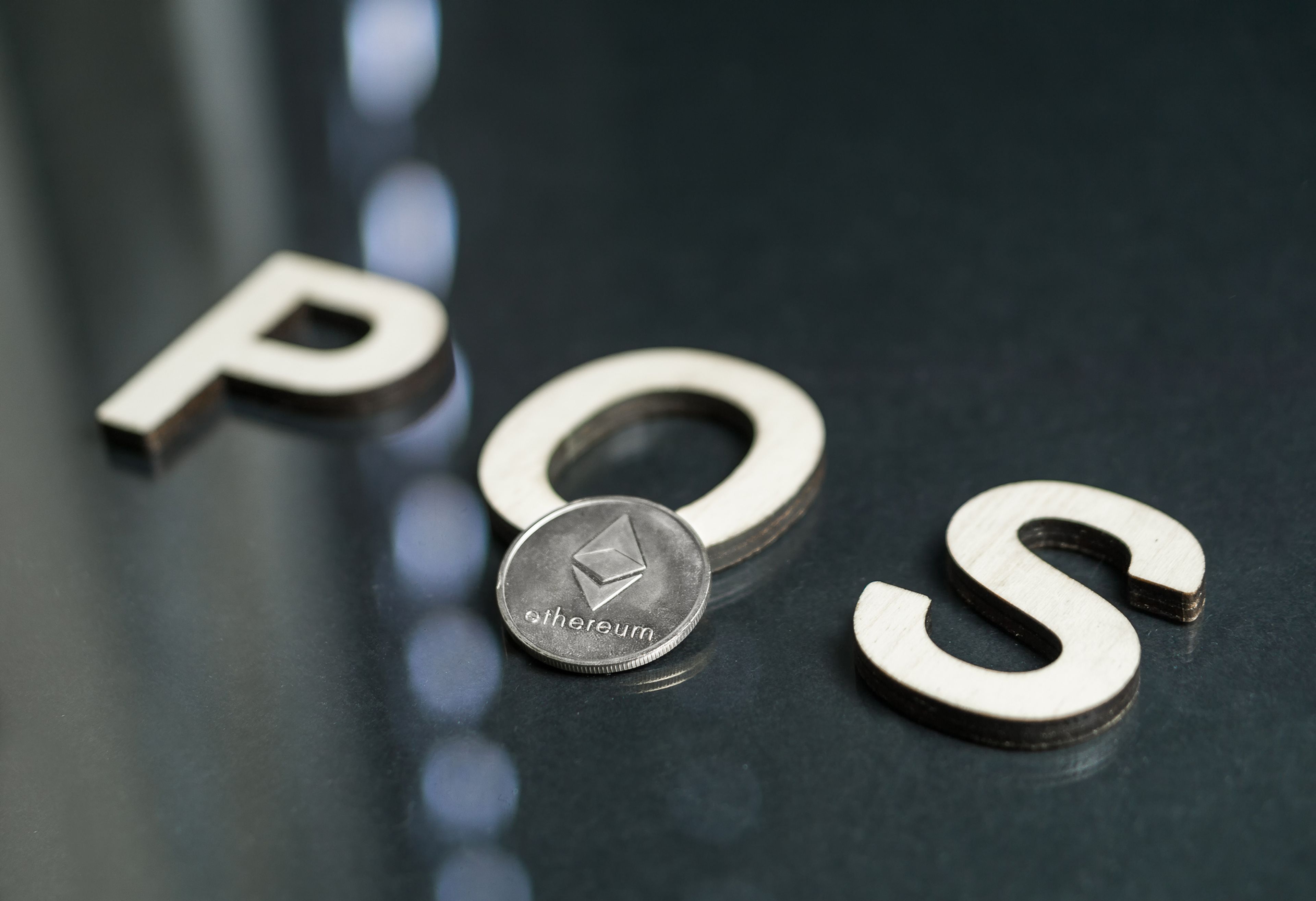 Una moneda de ethereum sobre las letras POS (Proof of Stake).