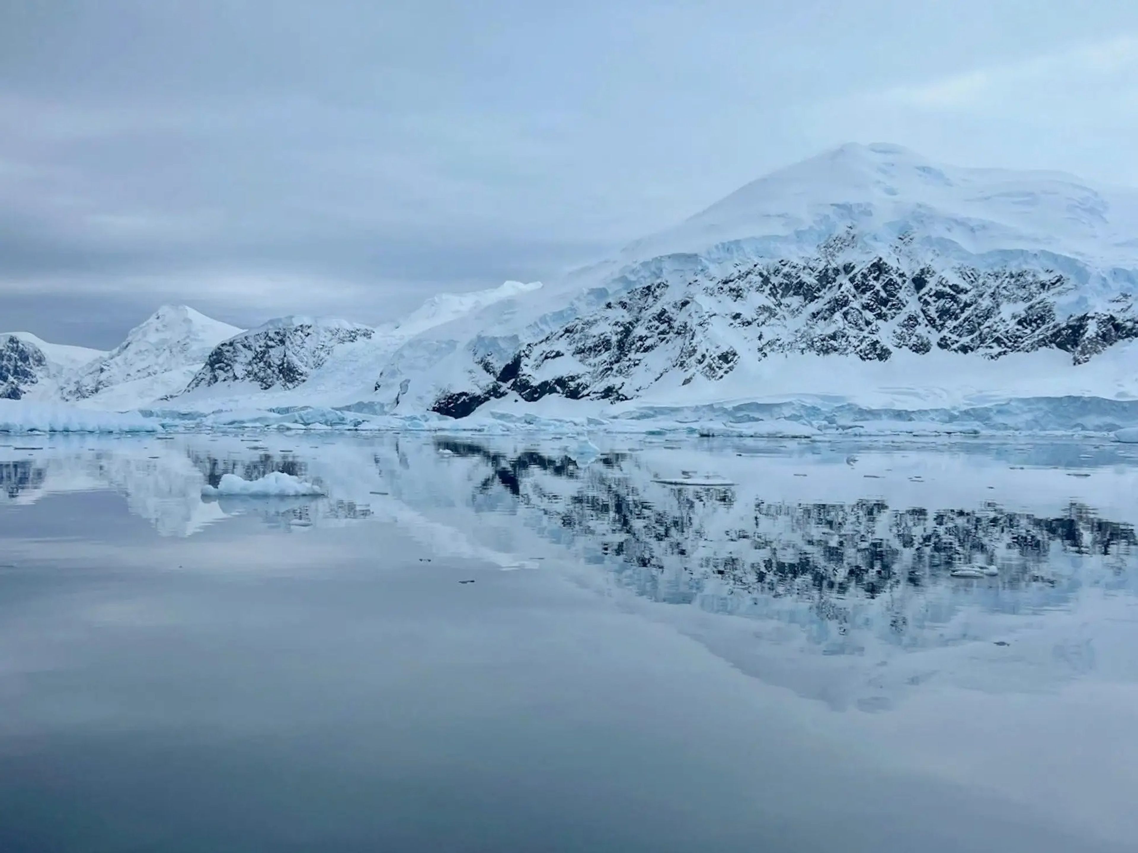 A mountain in Antarctica reflecting in the ocean.