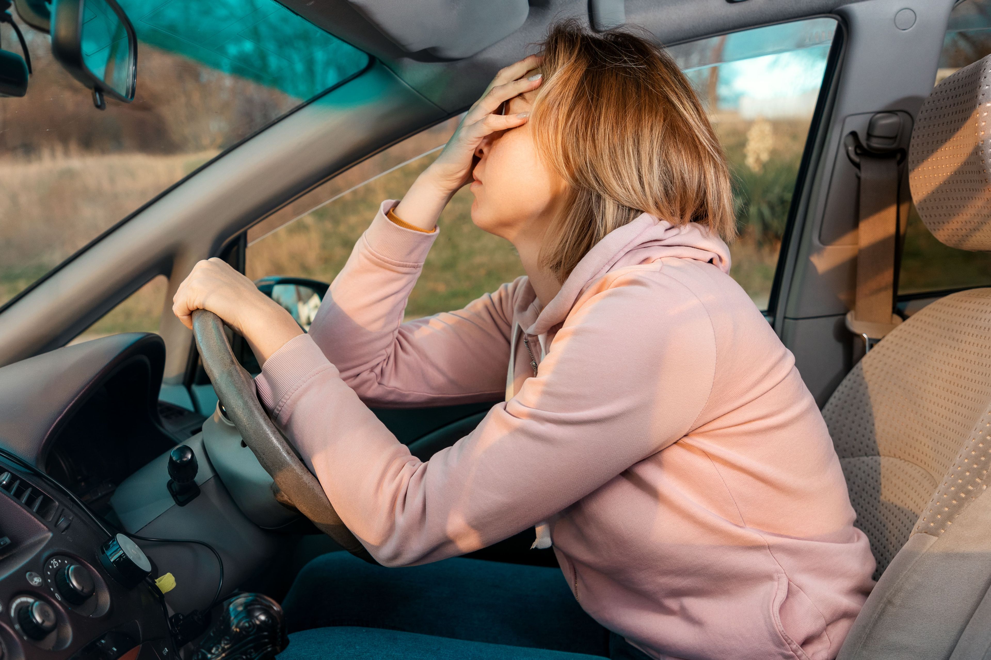 Una mujer conduce con dolor de cabeza
