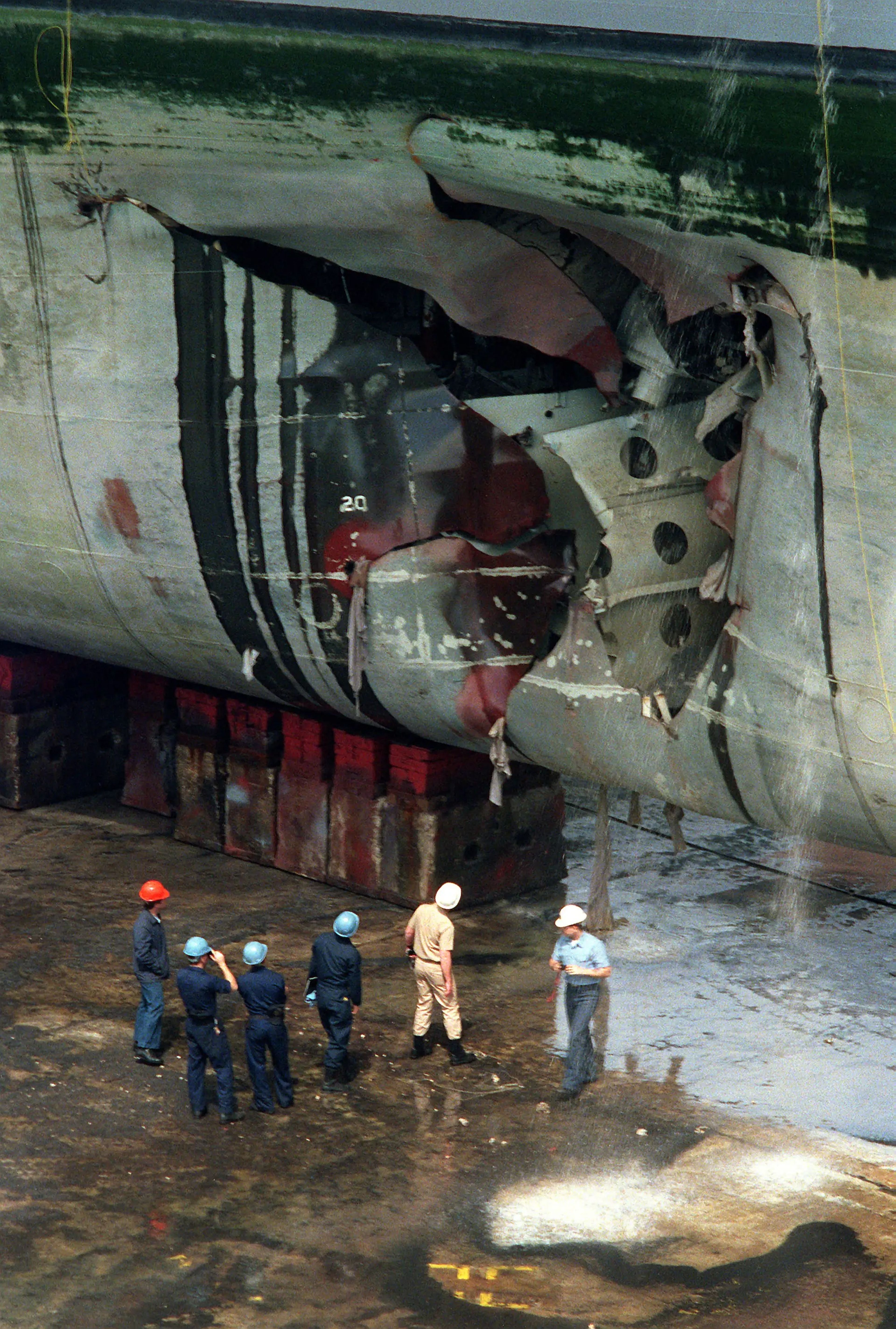 Equipos de reparación inspeccionan el buque de asalto USS Tripoli tras chocar contra una mina iraquí en el Golfo Pérsico el 18 de febrero de 1991.