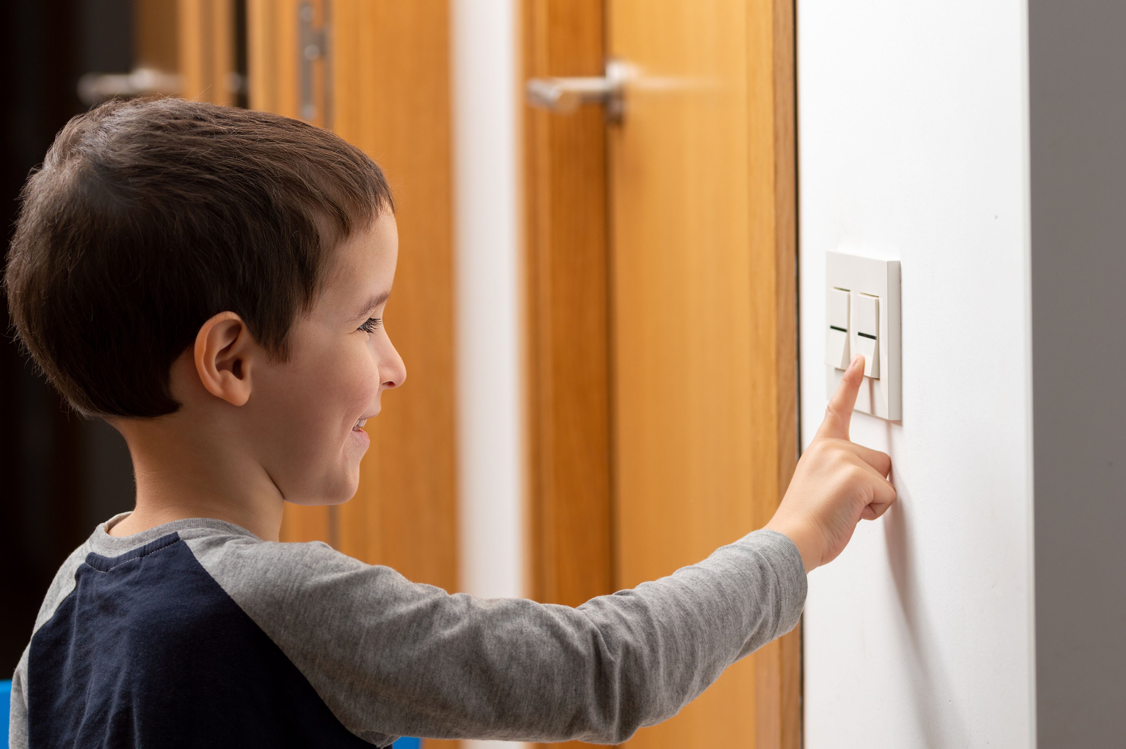 Un niño pulsa el interruptor de la luz.