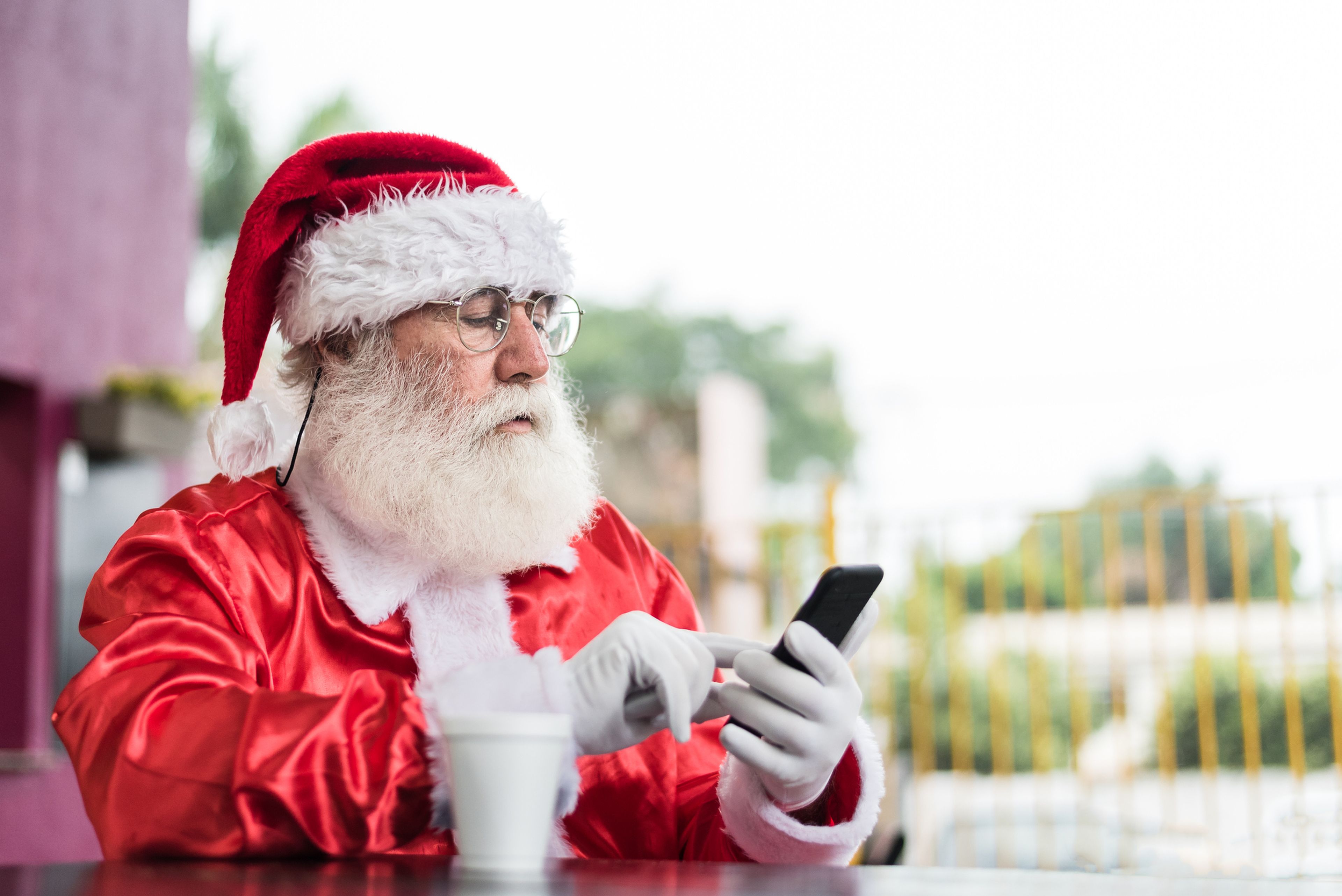 Papá Noel, con un móvil, mandando un mensaje