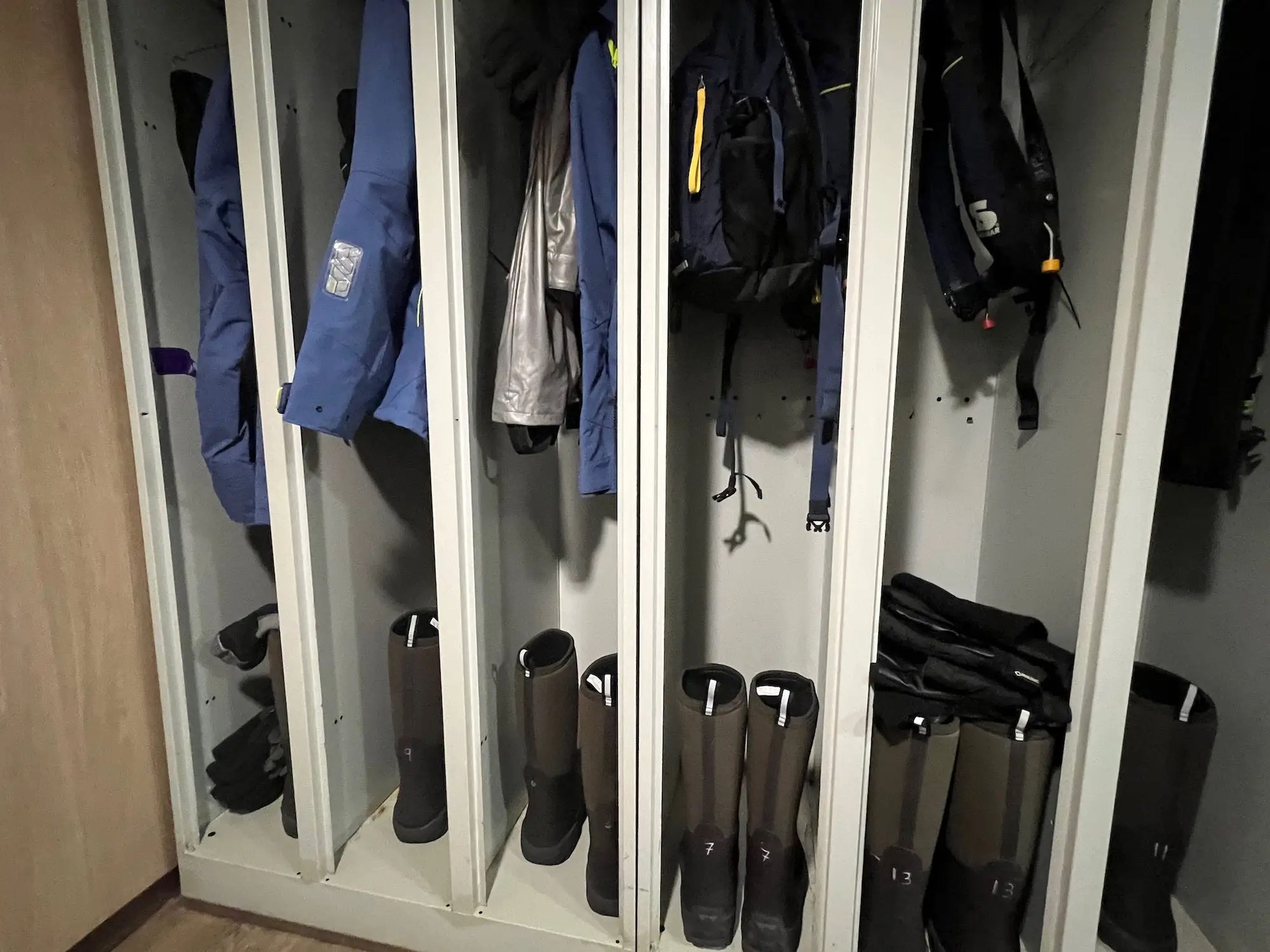 Parkas, muck boots, and backpacks in the mud room lockers.