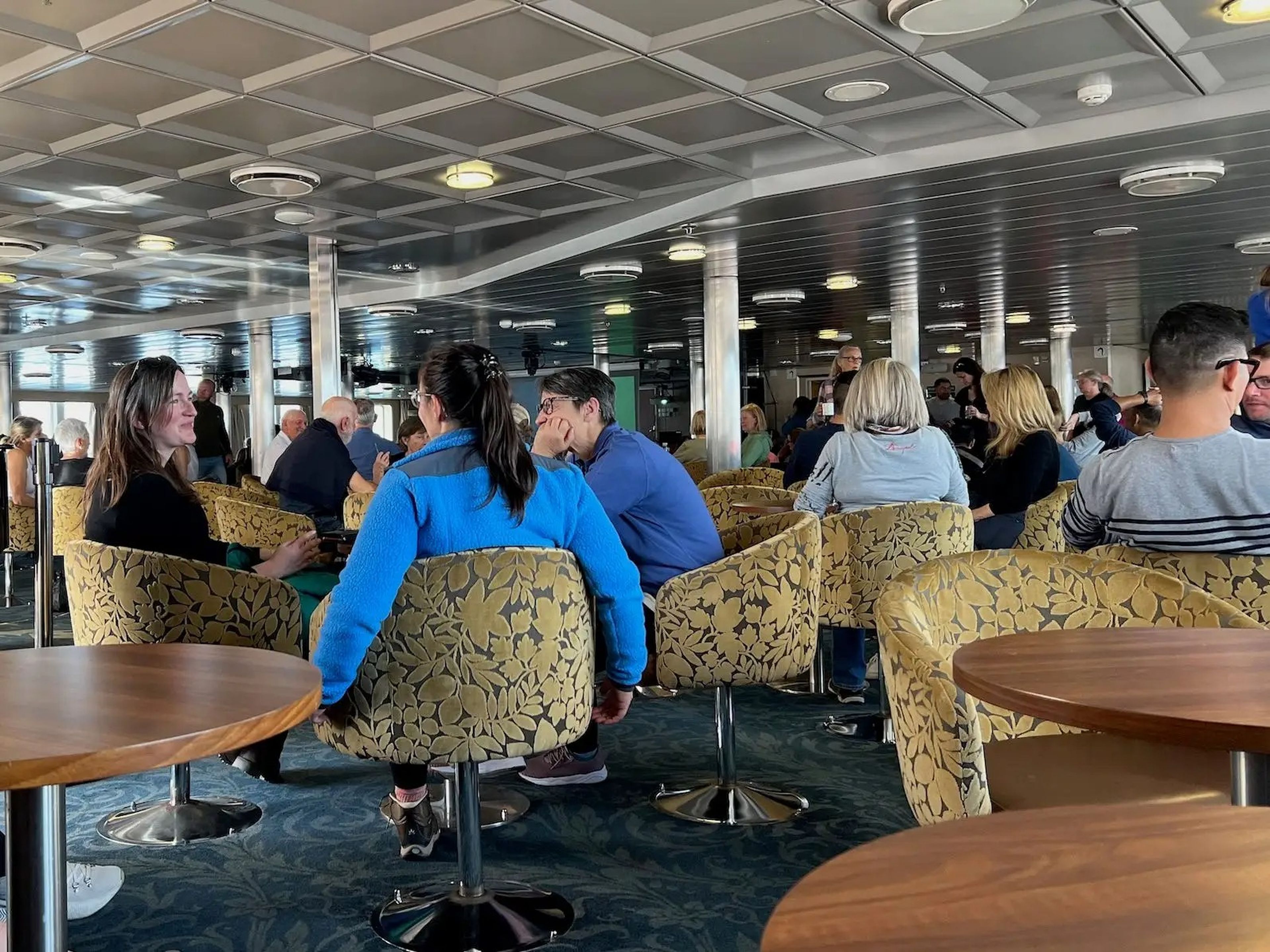 People sitting inside the Nautilus Lounge on embarkation day.
