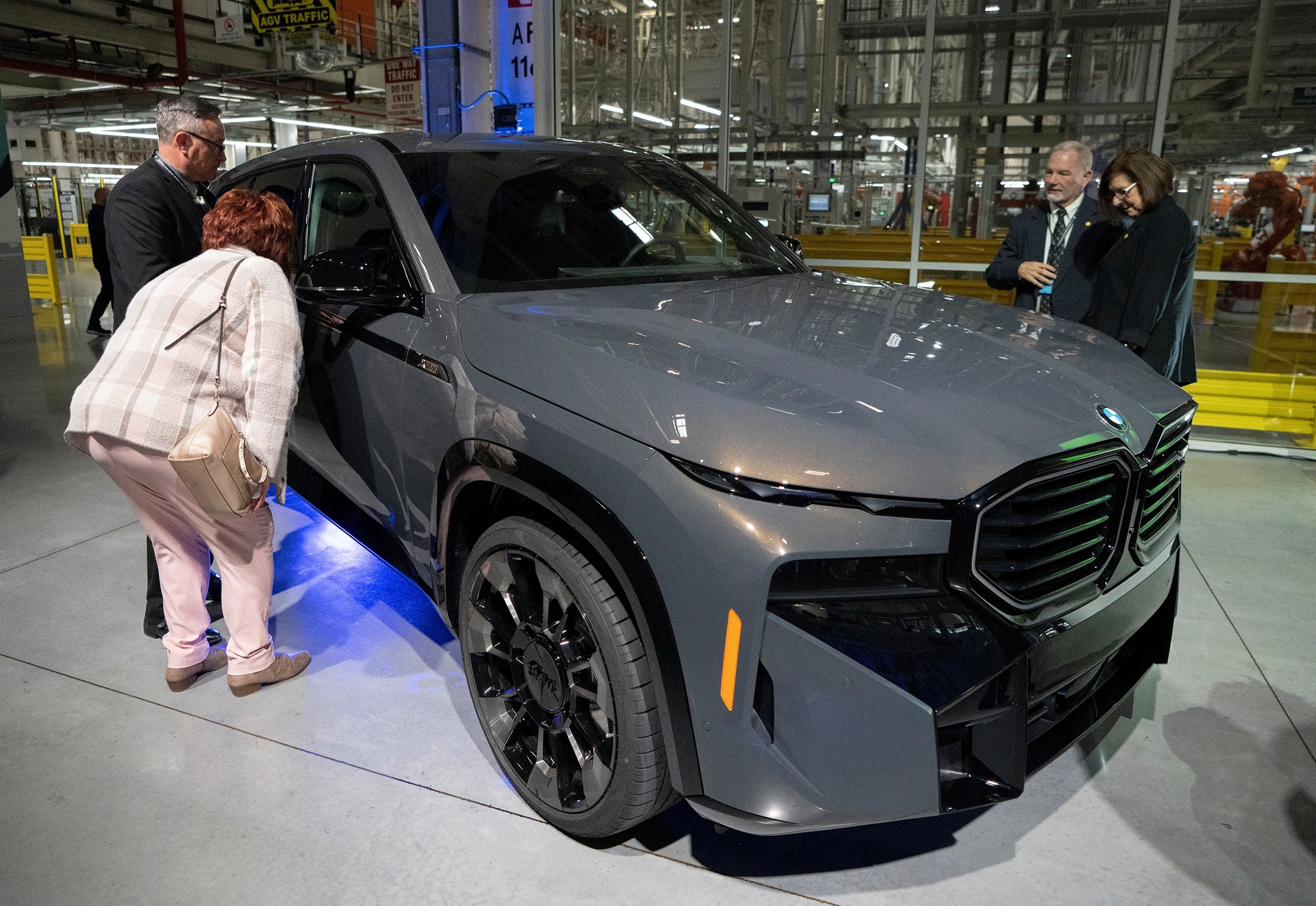 Visitantes observan el nuevo BMW XM híbrido-eléctrico en la planta de fabricación de BMW en Carolina del Sur.