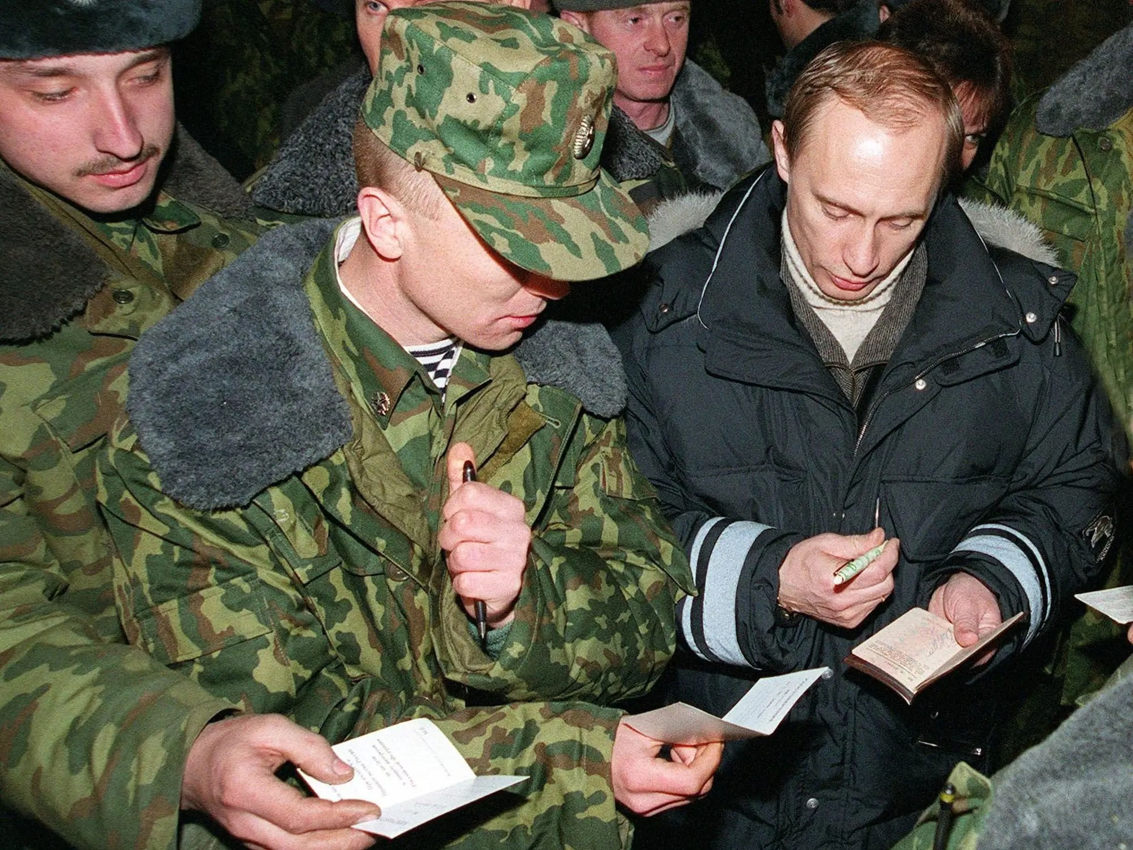 Putin, entonces presidente en funciones de Rusia, firma autógrafos para soldados en Chechenia el 1 de enero de 2000.