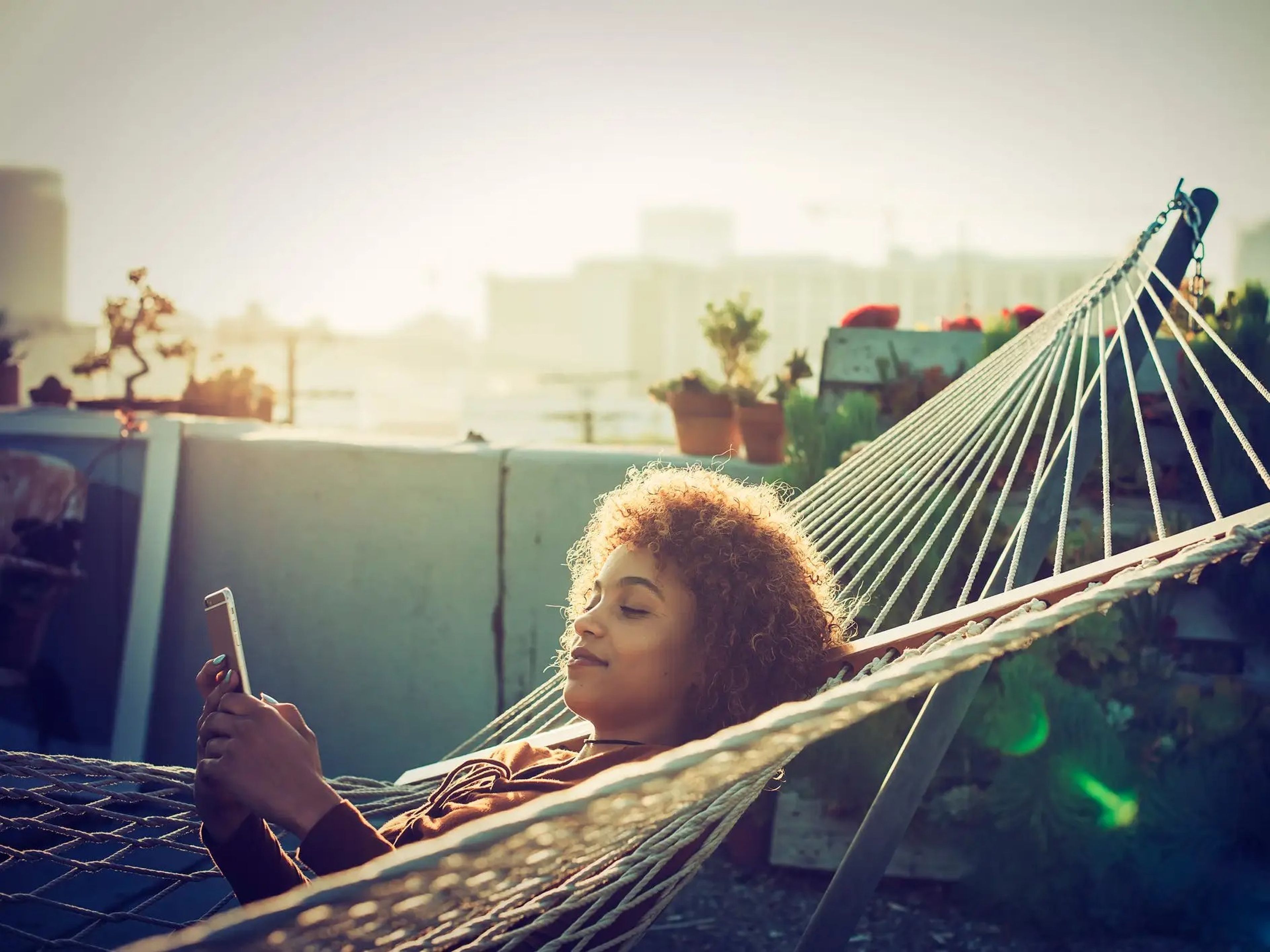 woman lying in a hammock texting
