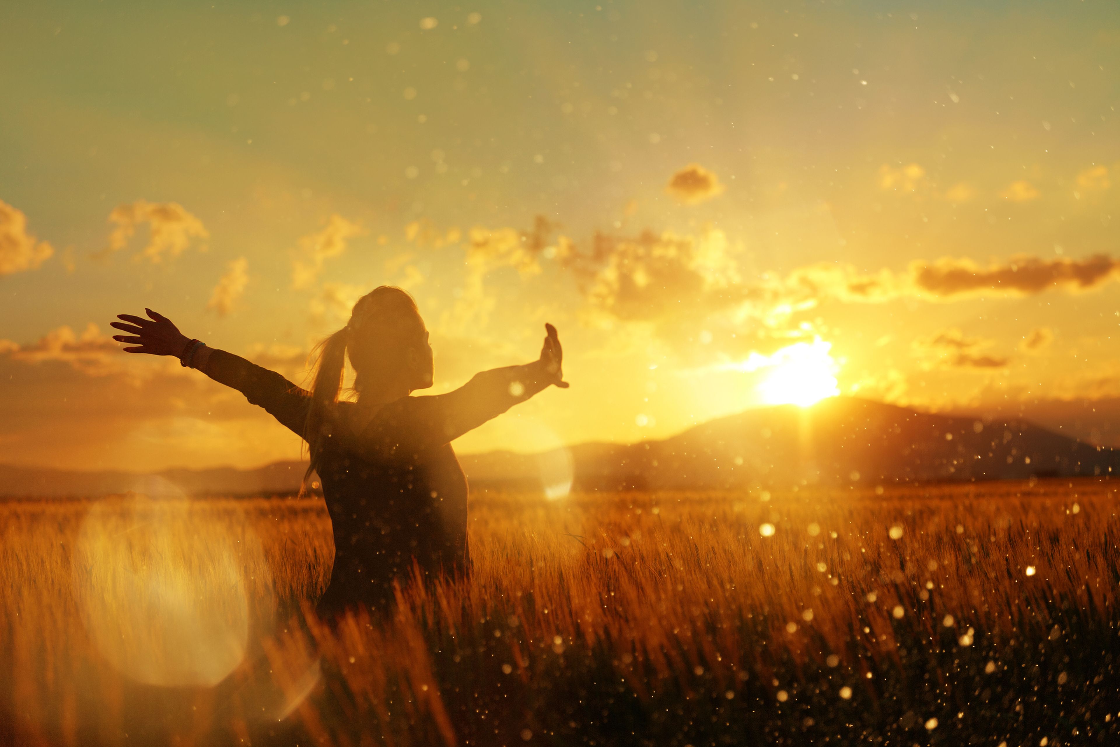 Imagen de una mujer en el campo, frente a puesta de sol: vida