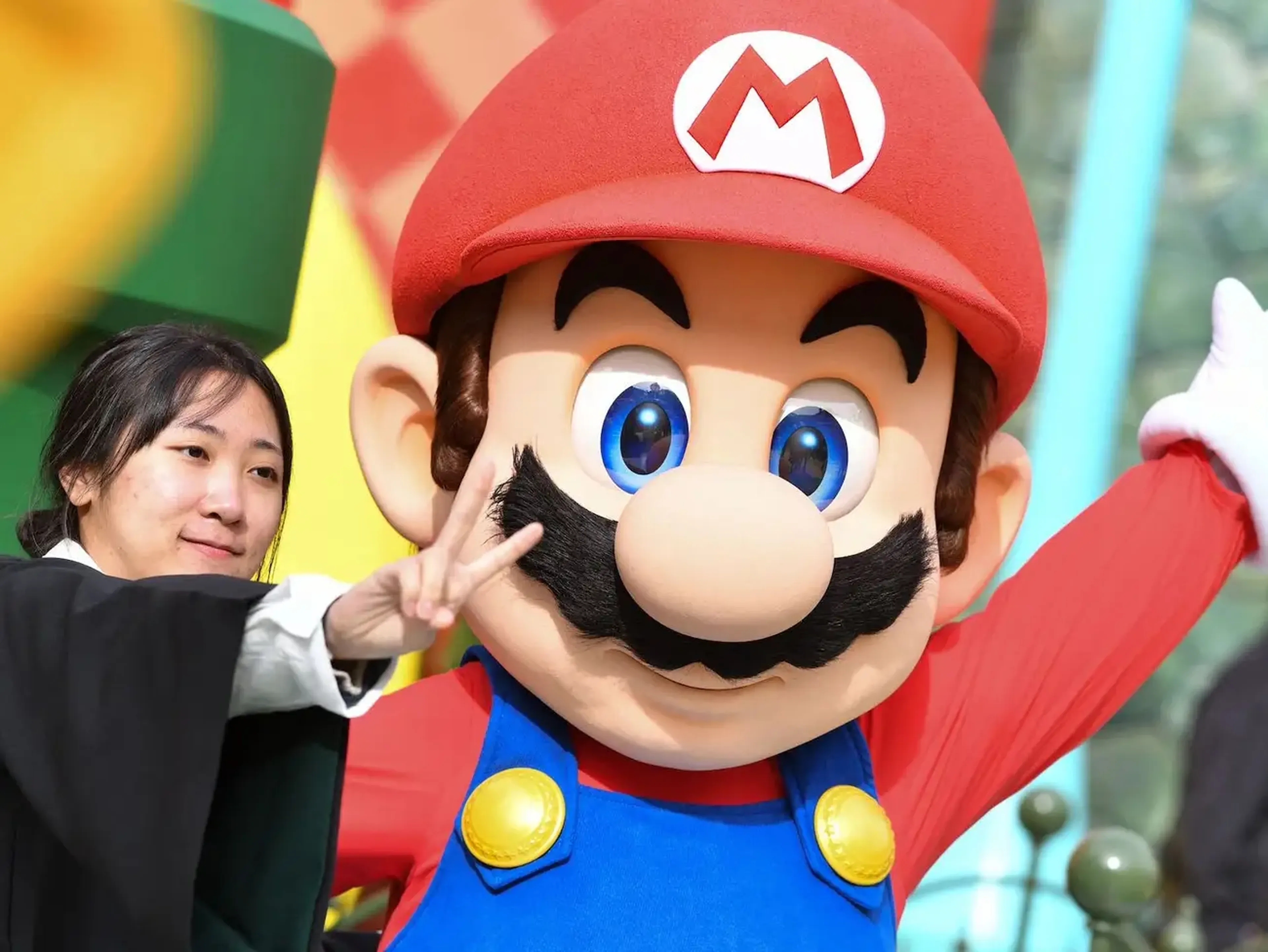 Un invitado se toma una foto con Mario durante una vista previa de Super Nintendo World en Universal Studios en Los Ángeles, California, el 13 de enero de 2023.