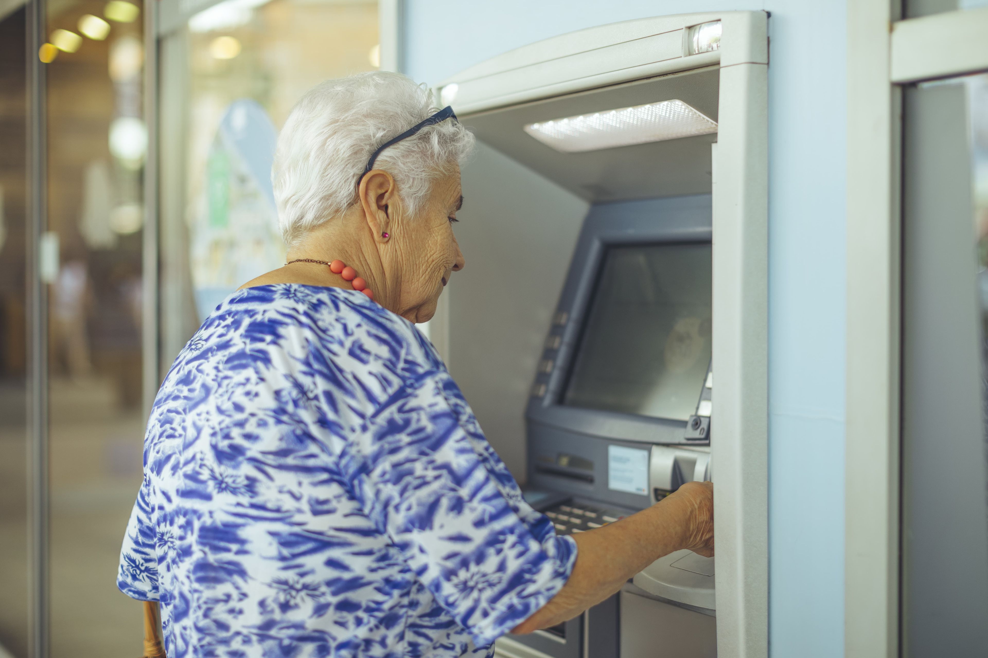 Mujer mayor en el cajero de un banco
