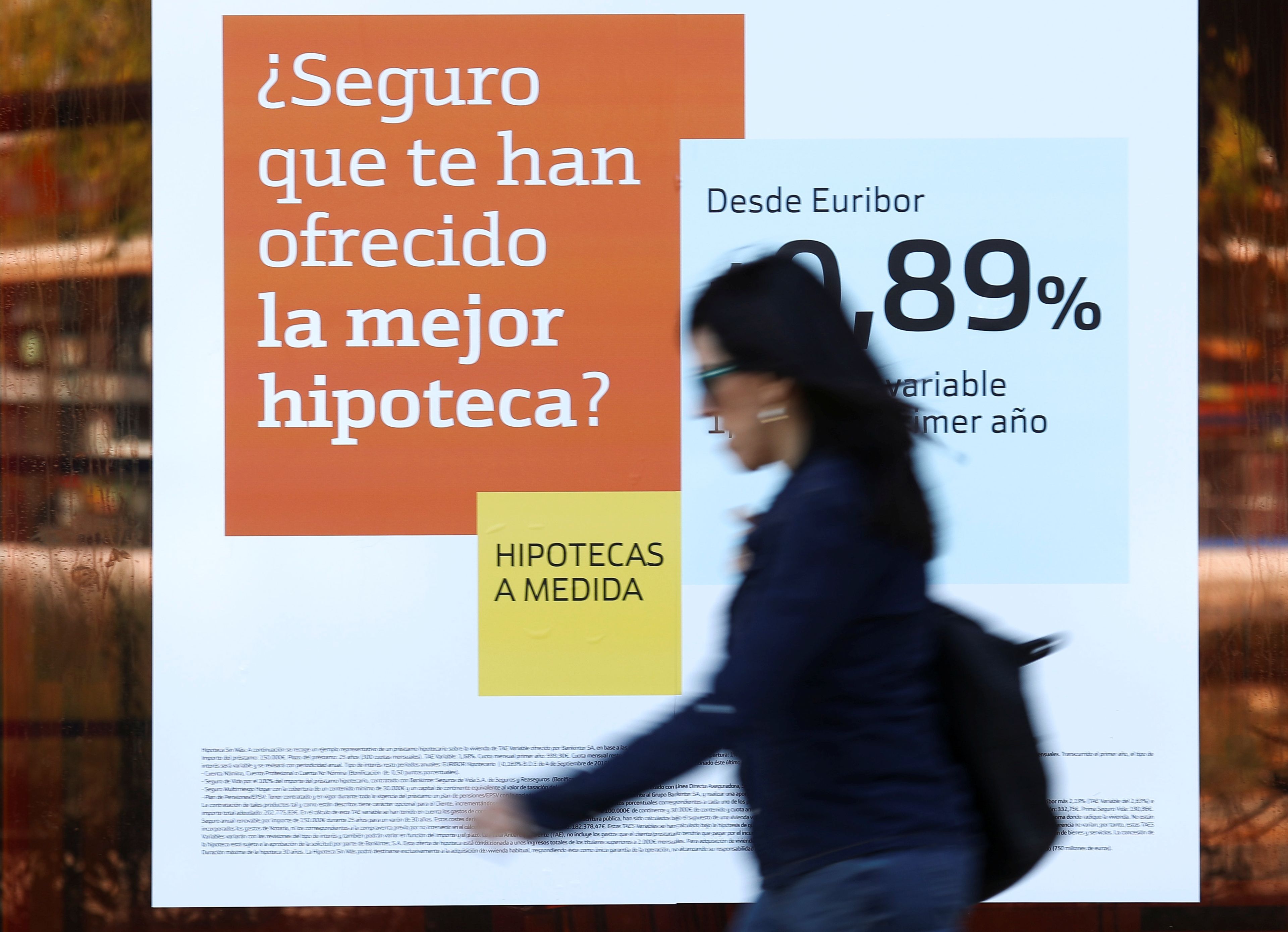 Una mujer pasa por delante de un anuncio de hipoteca de un banco, euríbor