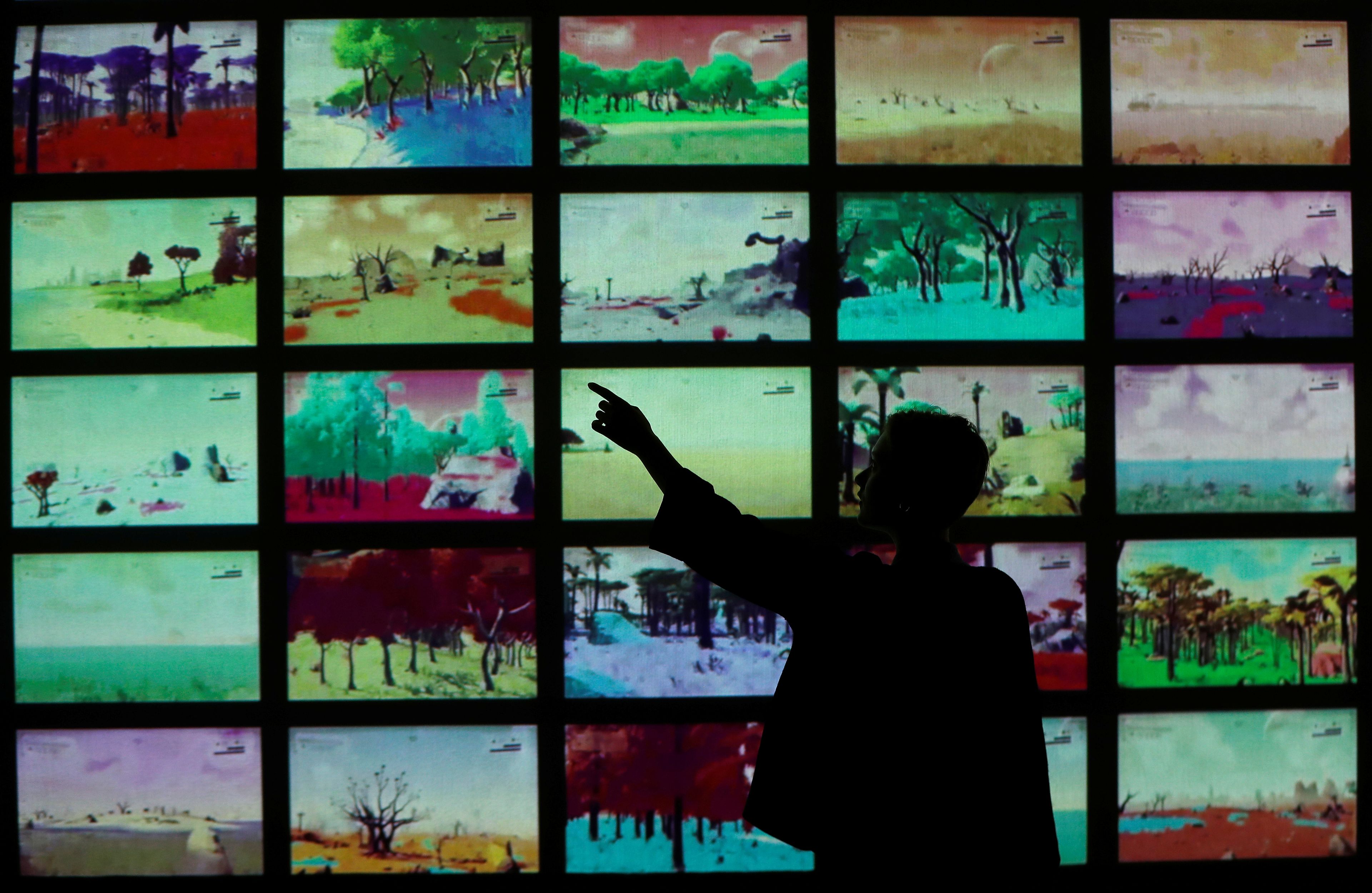 Una persona interactúa con pantallas en una feria sobre diseño de videojuegos en Londres.