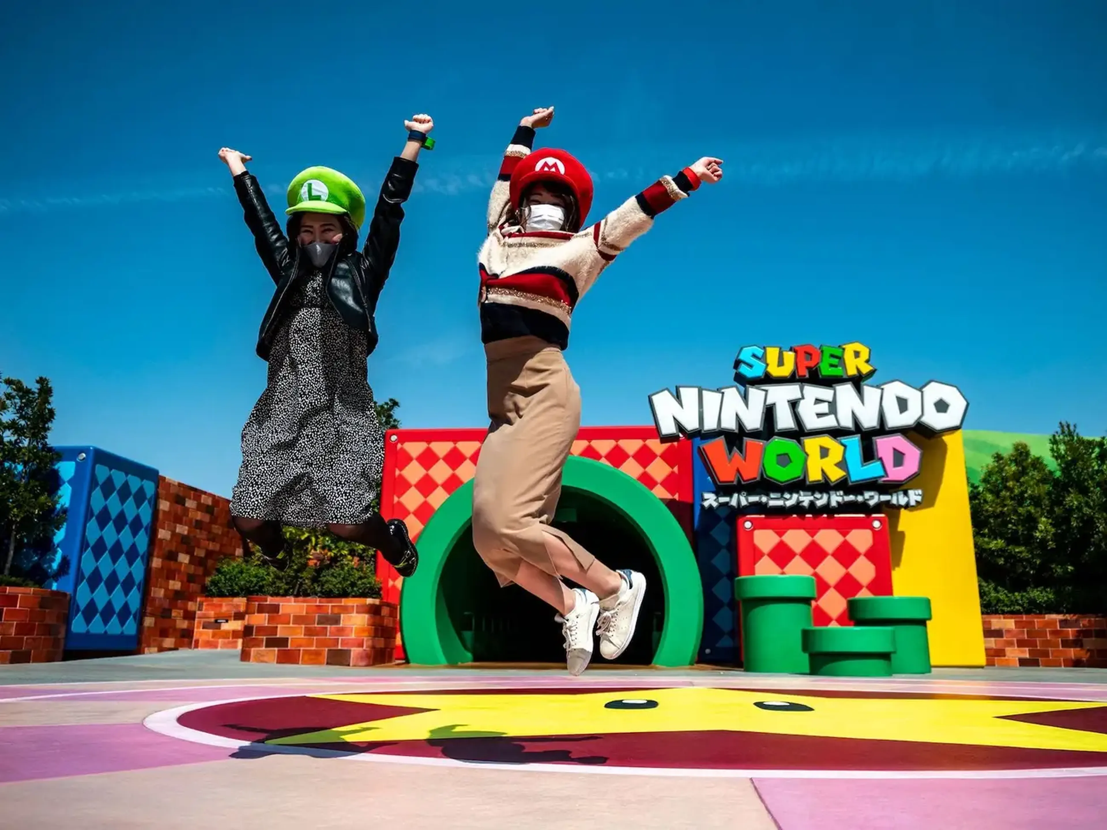 En esta imagen tomada en 2021, los fanáticos de Universal Studio Japan posan en la entrada de Super Nintendo World, durante una vista previa para los medios en el parque temático de Osaka.