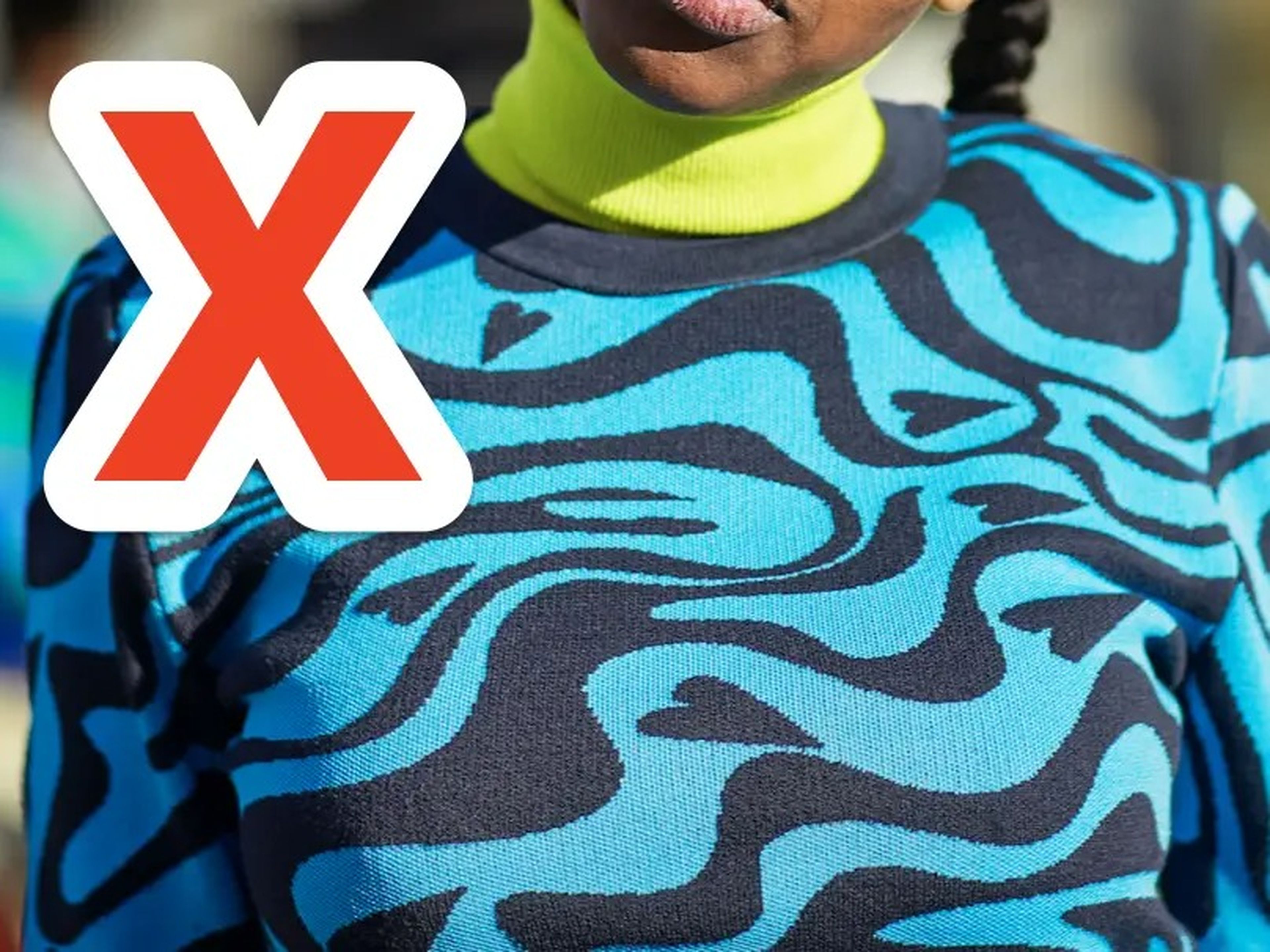 x over woman wearing a blue and black patterned sweater with a neon turtleneck underneath