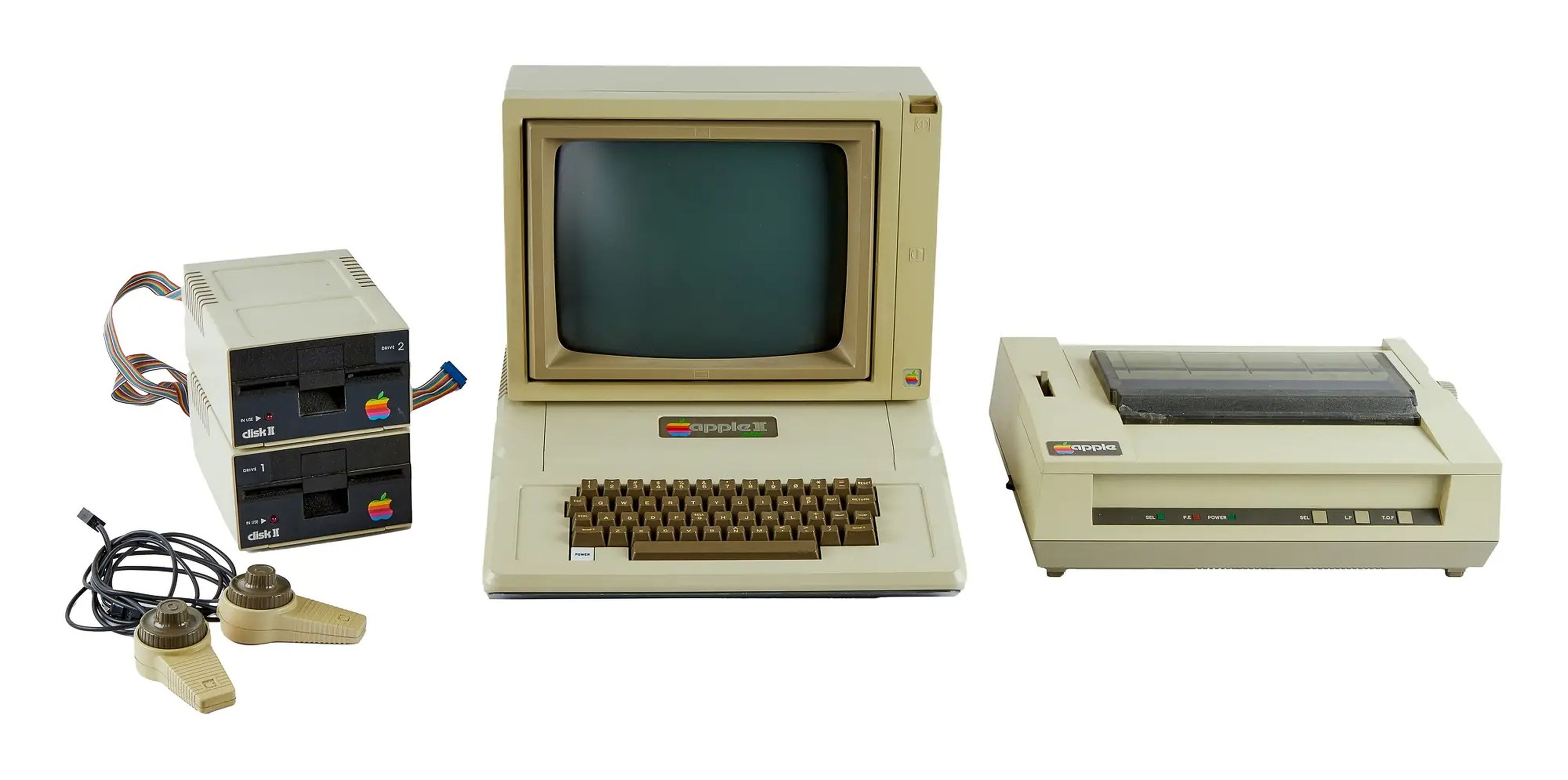 1979-1982 Apple II Plus Computer with a monitor, two disk drives on the left of the computer, two game paddles on the far left, and a printer on the right of the printer