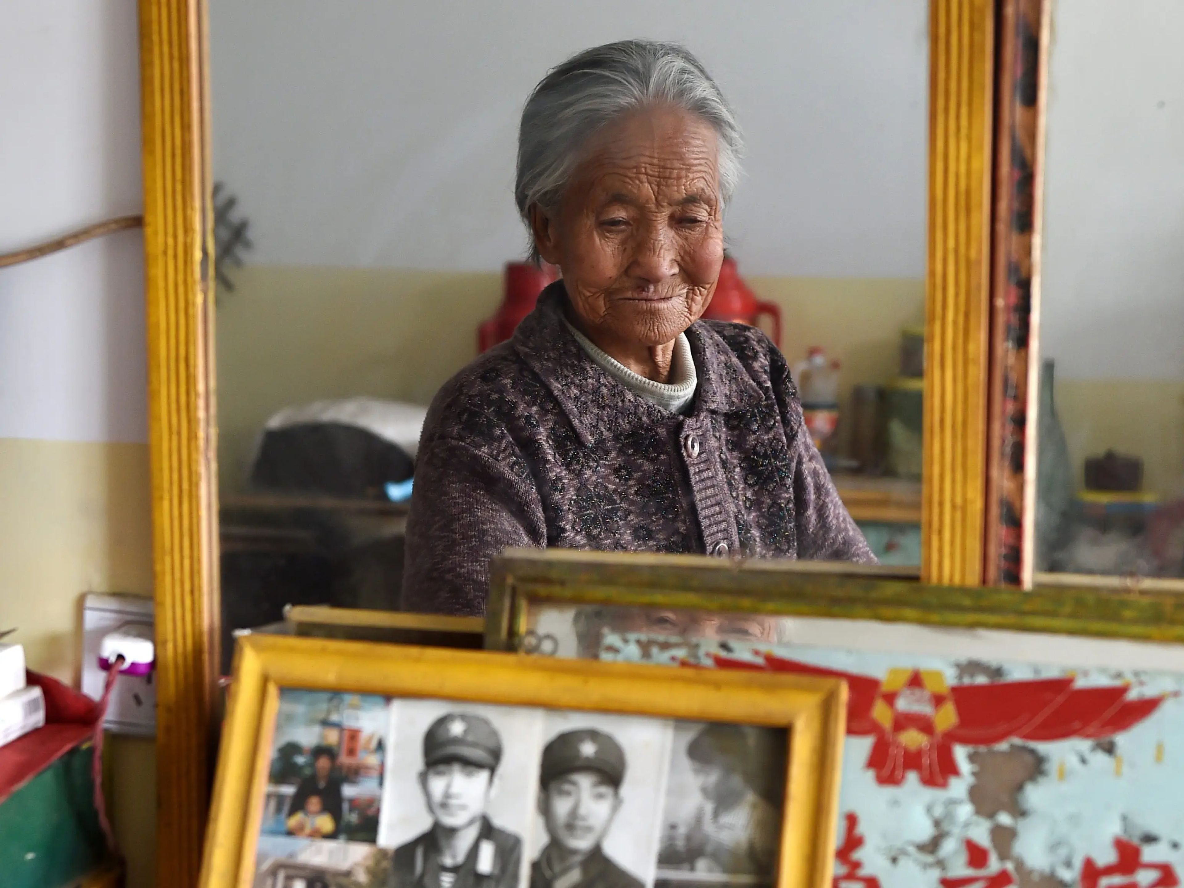 Una anciana observa fotos familiares en la residencia de ancianos de la aldea de Checheng, en el condado de Ji, en la provincia de Shanxi, en el norte de China, el 17 de noviembre de 2015.