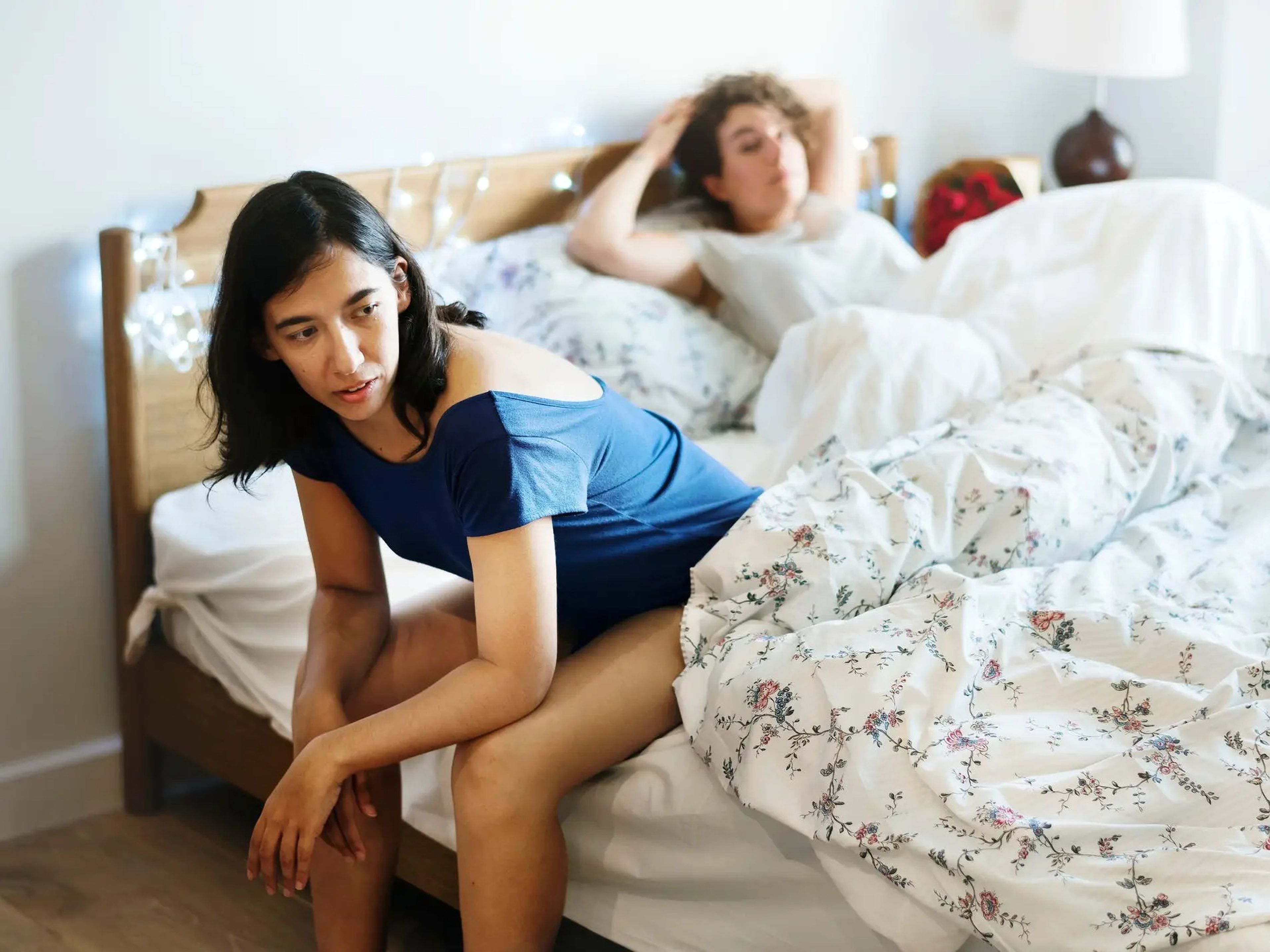 couple in bed looking irritated with each other