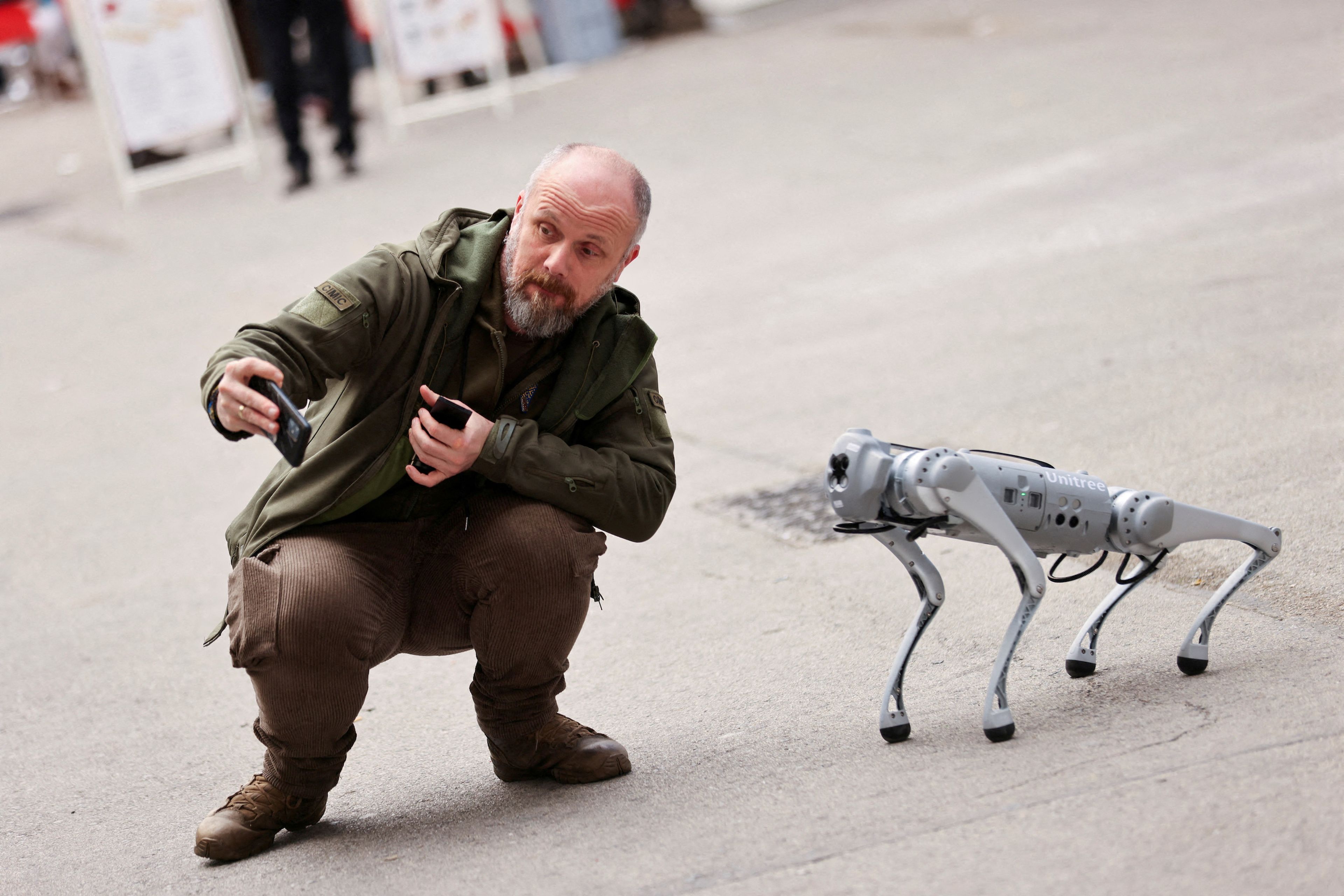 Un hombre se hace un 'selfie' con un perro robótico durante el Mobile World Congress que se celebra estos días en Barcelona.