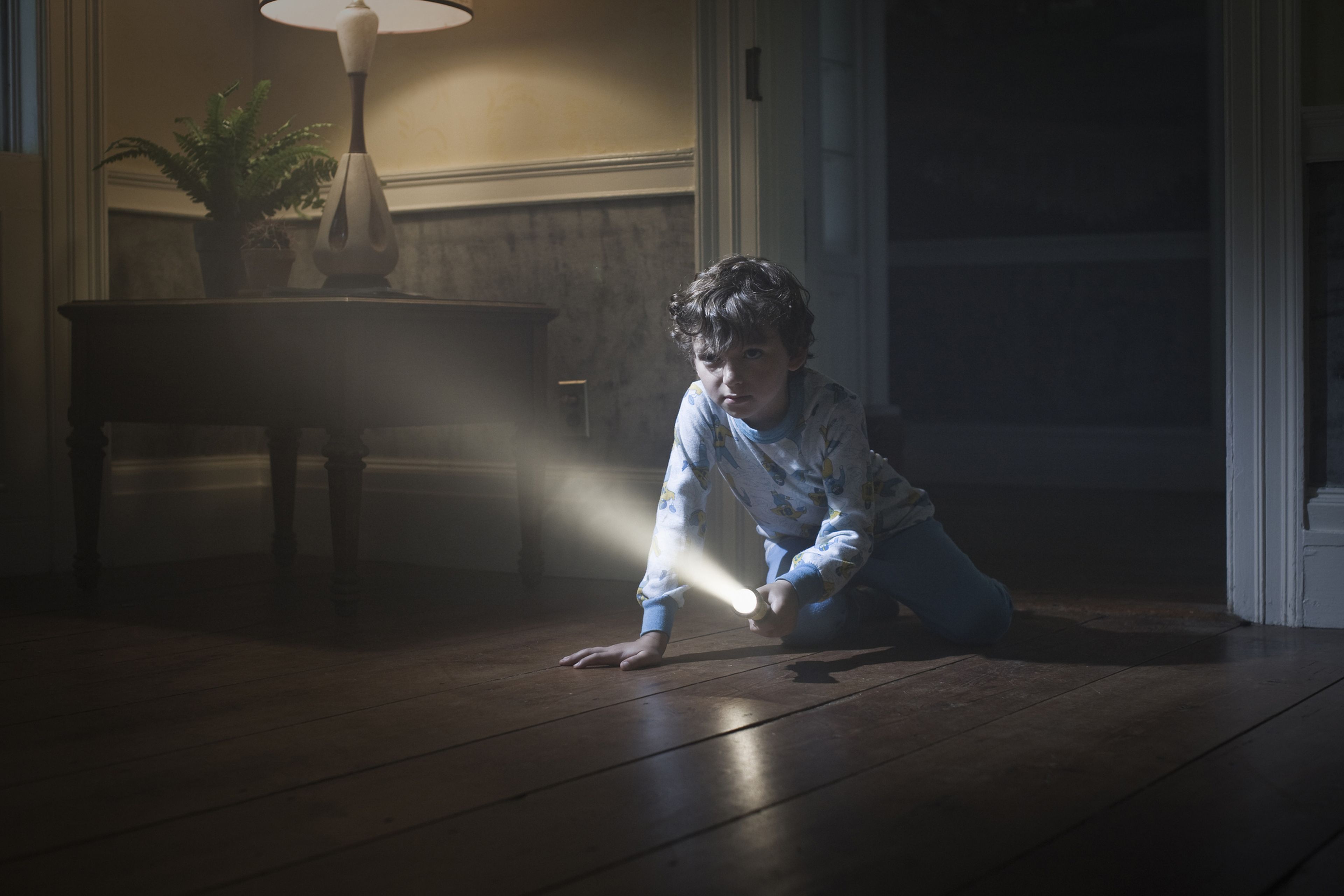 Un niño gatea con una linterna.
